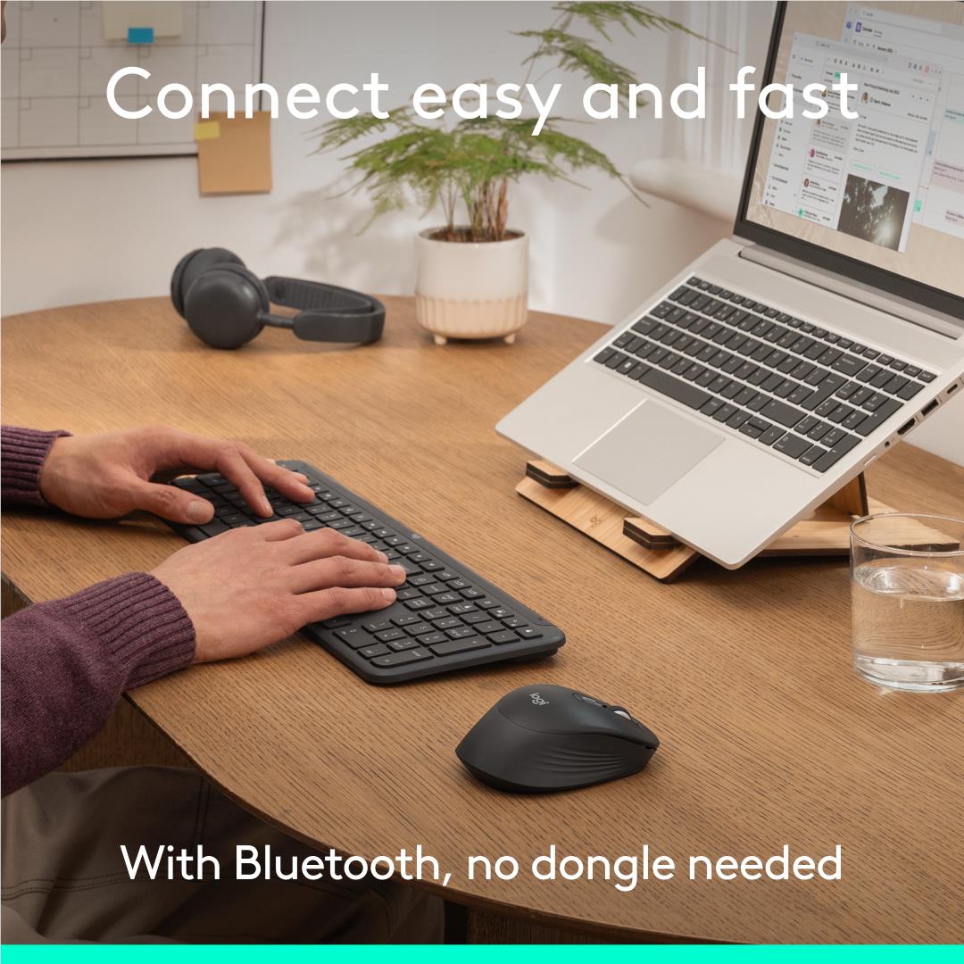Logitech graphite quiet-click mouse near keyboard and laptop on a desk