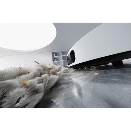 White robot vacuum cleaning fluffy debris on floor