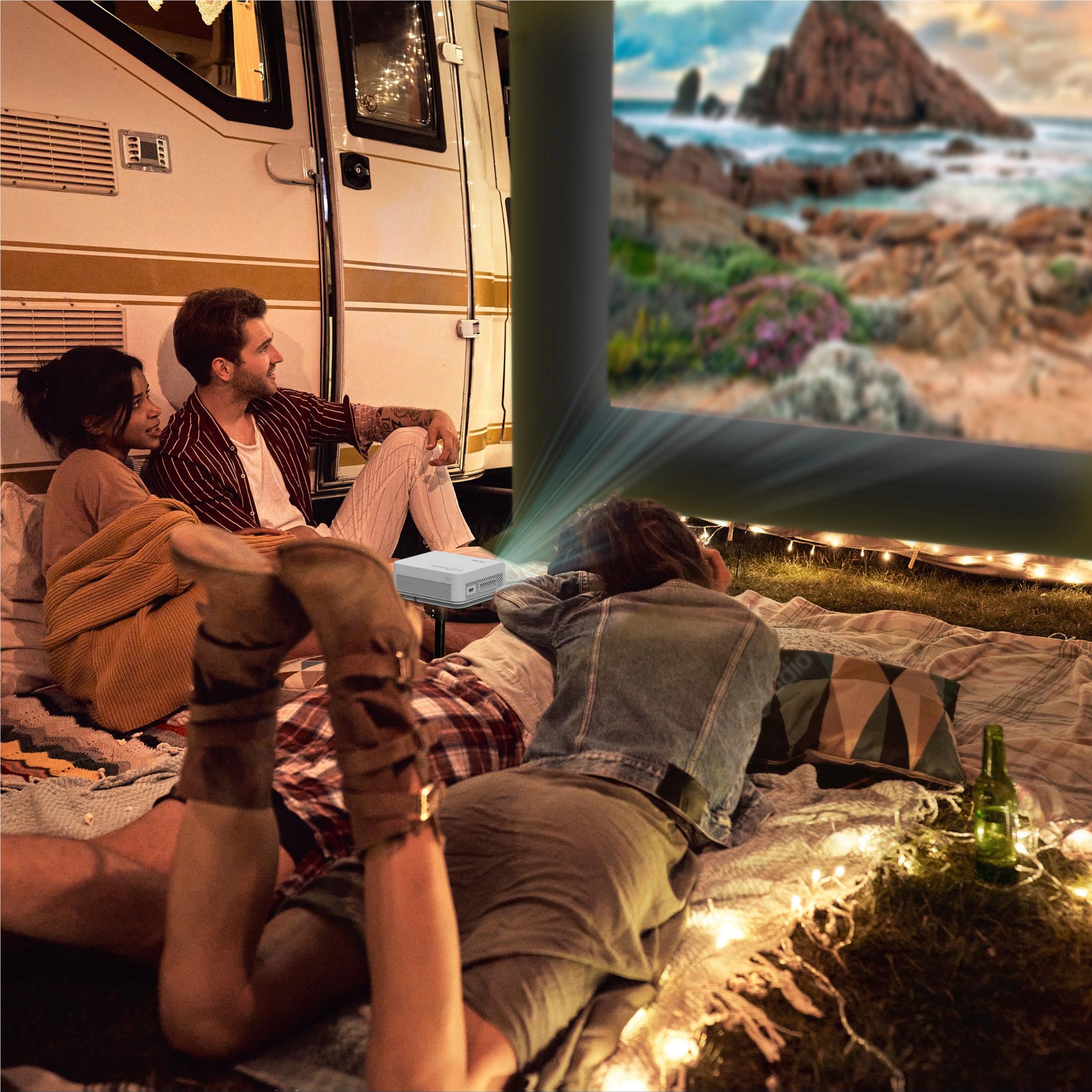 Outdoor cinema setup with inflatable screen and white projector showing video for campers