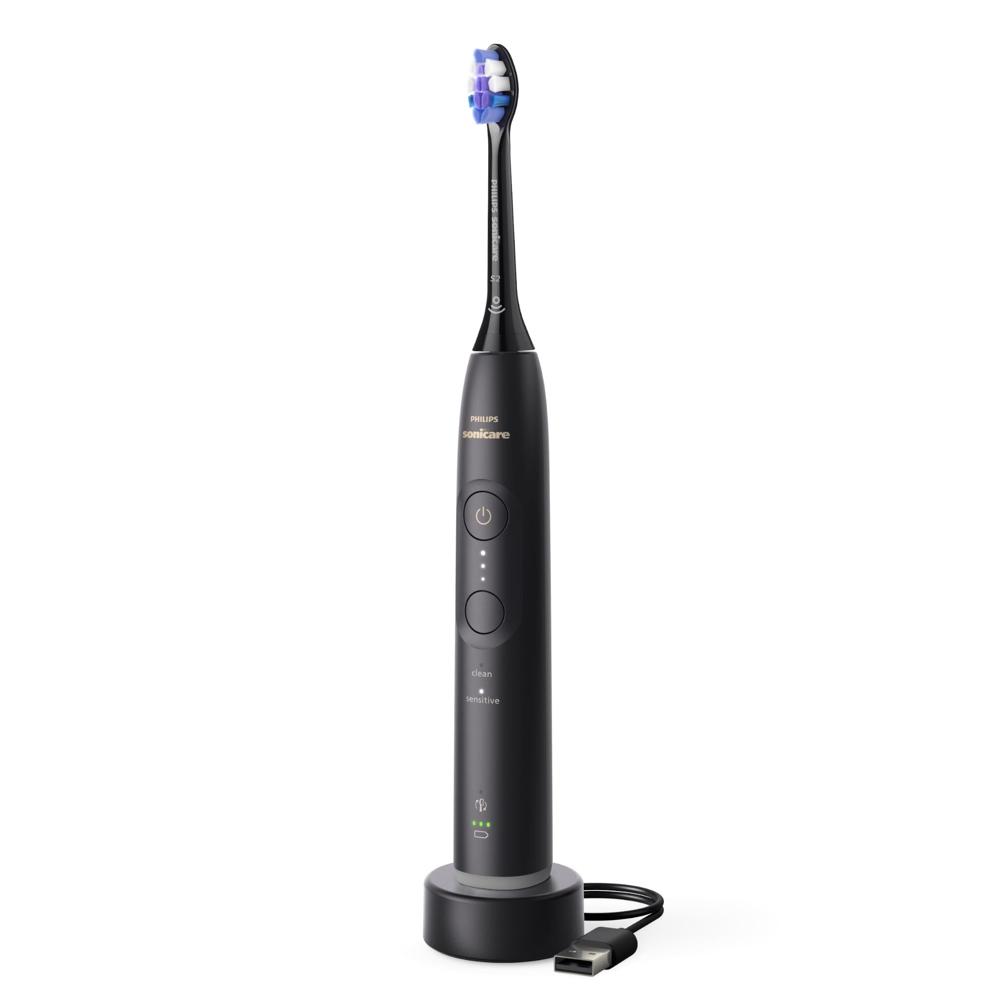 Black electric toothbrush standing with blue bristle brush head