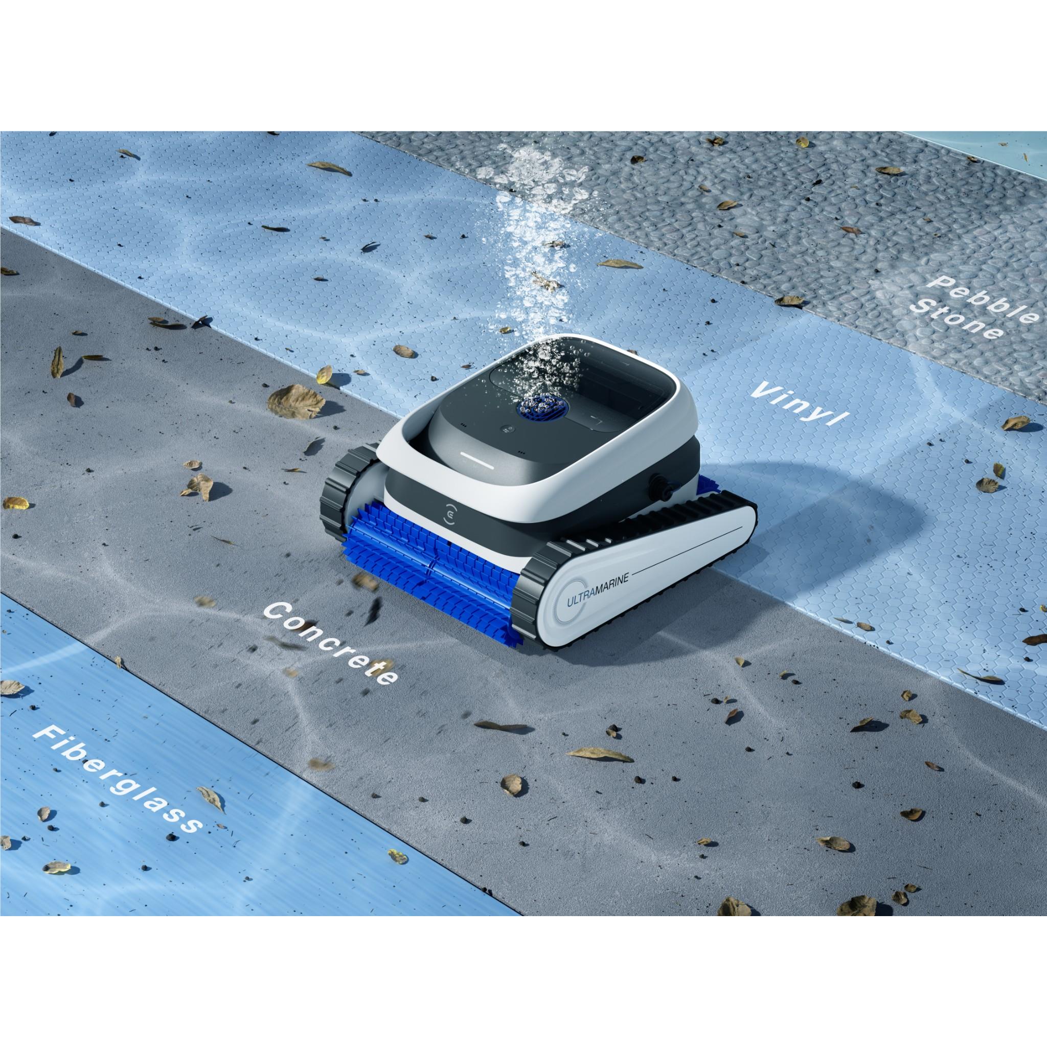 White robot pool cleaner on pool surface with blue rotating brush roller