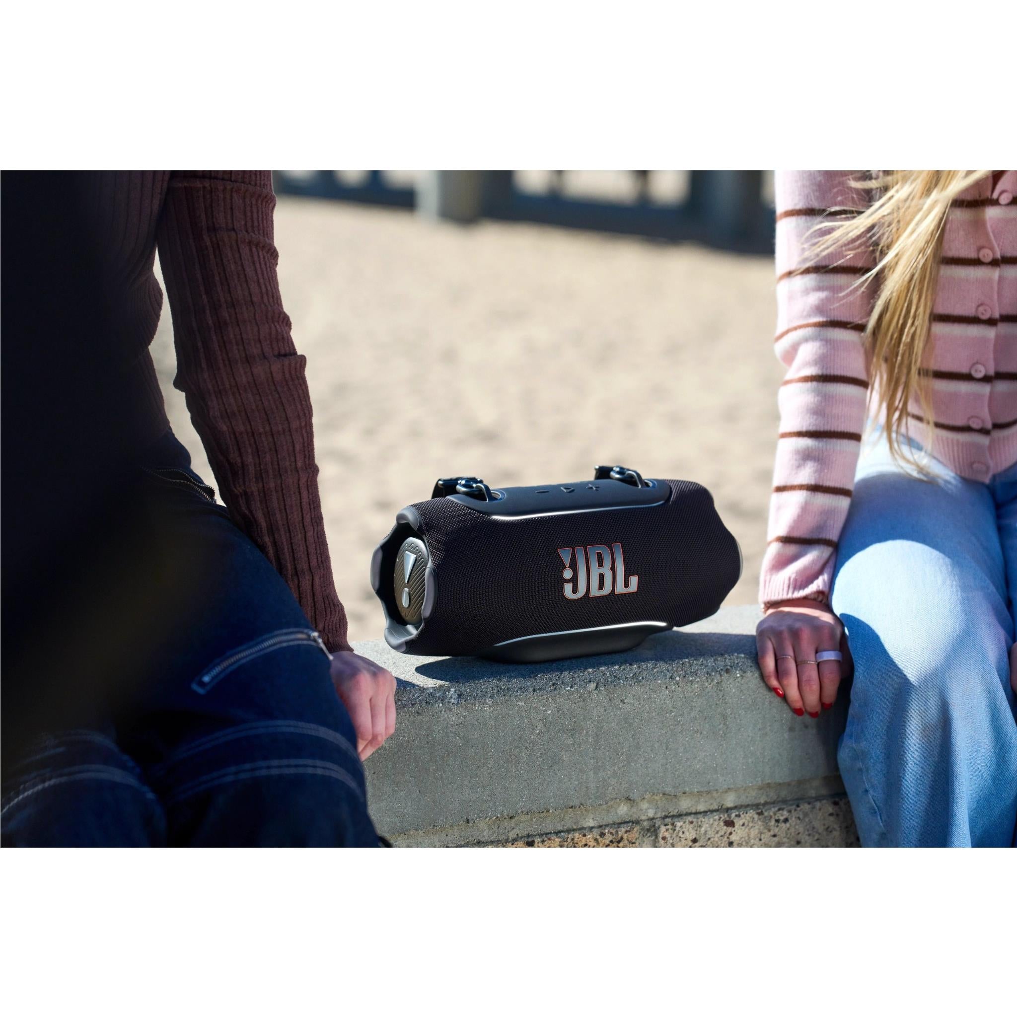 Black JBL Xtreme 5 portable speaker resting on steps with JBL logo facing up