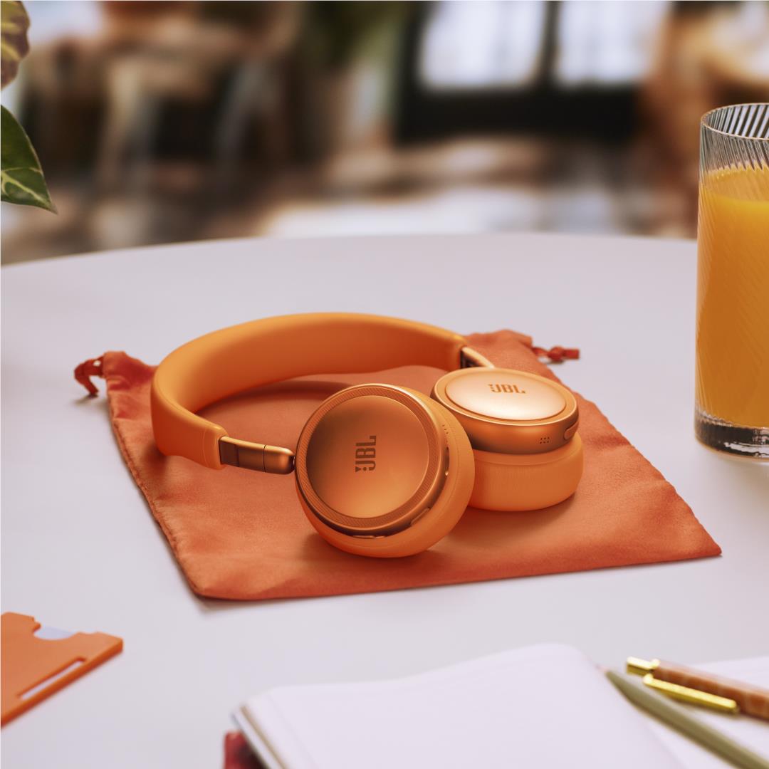Orange JBL over-ear headphones resting on an orange pouch with coiled cable nearby