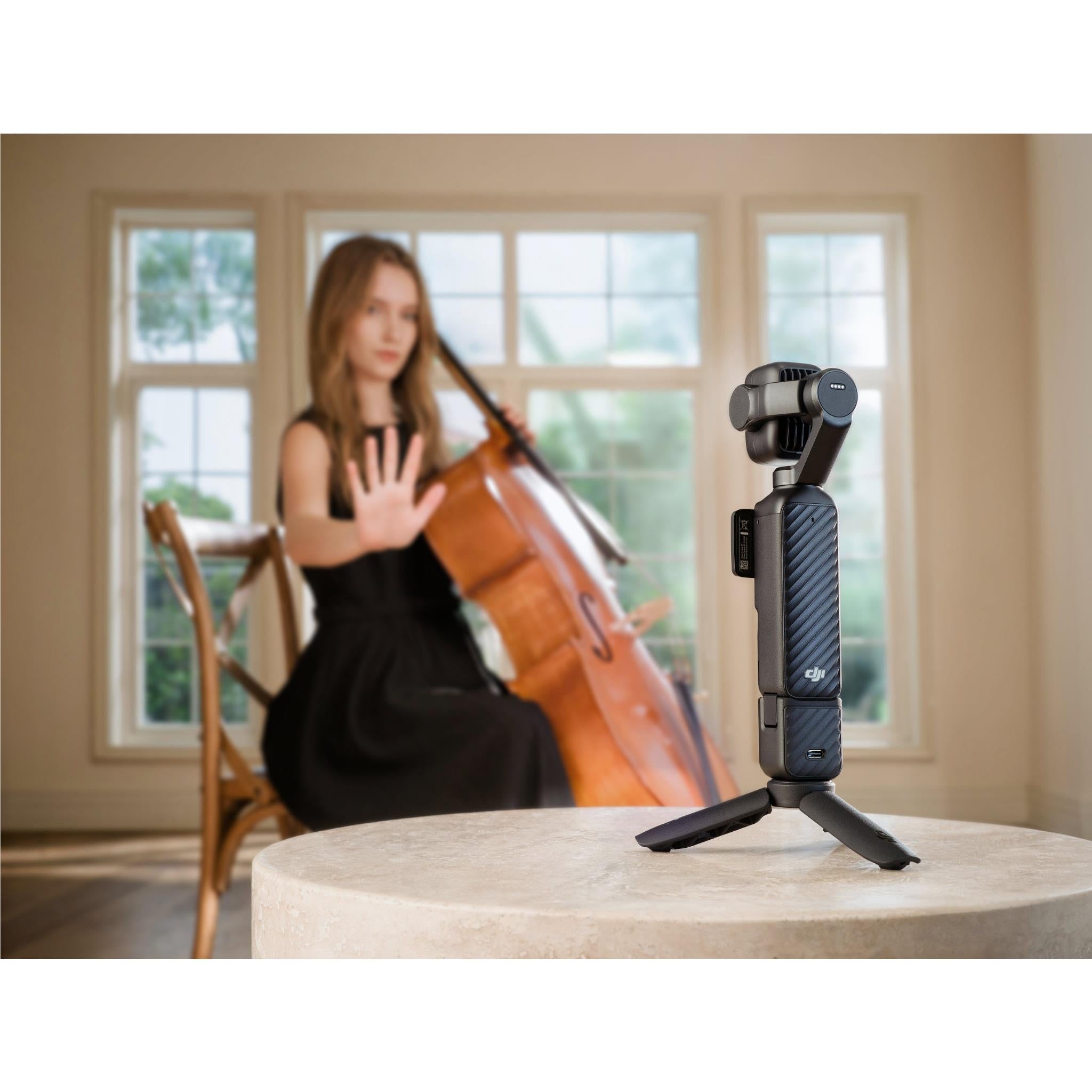 Black gimbal camera on tabletop tripod stand with side display panel