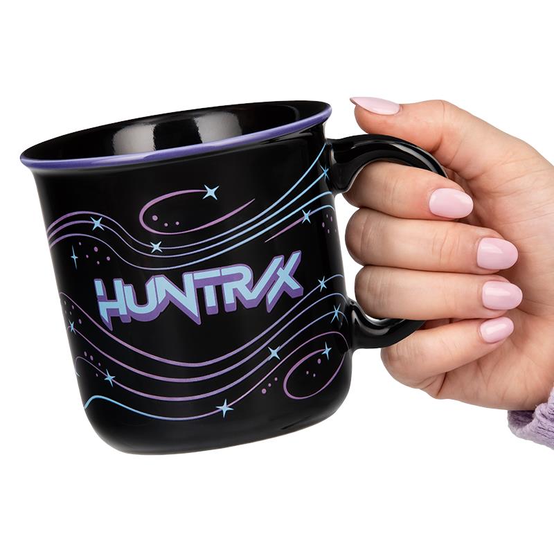 Black ceramic mug with purple 'HUNTRIX' graphic, held by hand