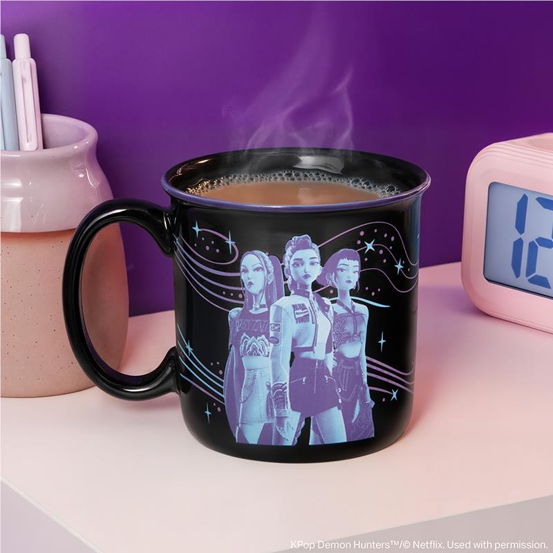 Black ceramic mug with purple character graphic and steam rising from top