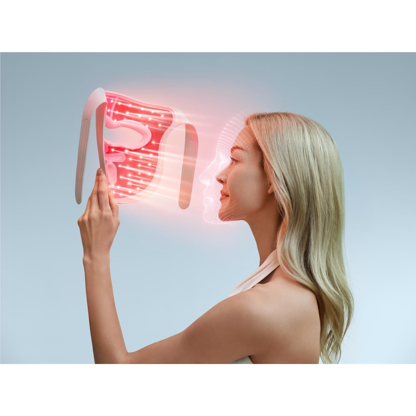 Person wearing LED face mask with red lights across the face panel