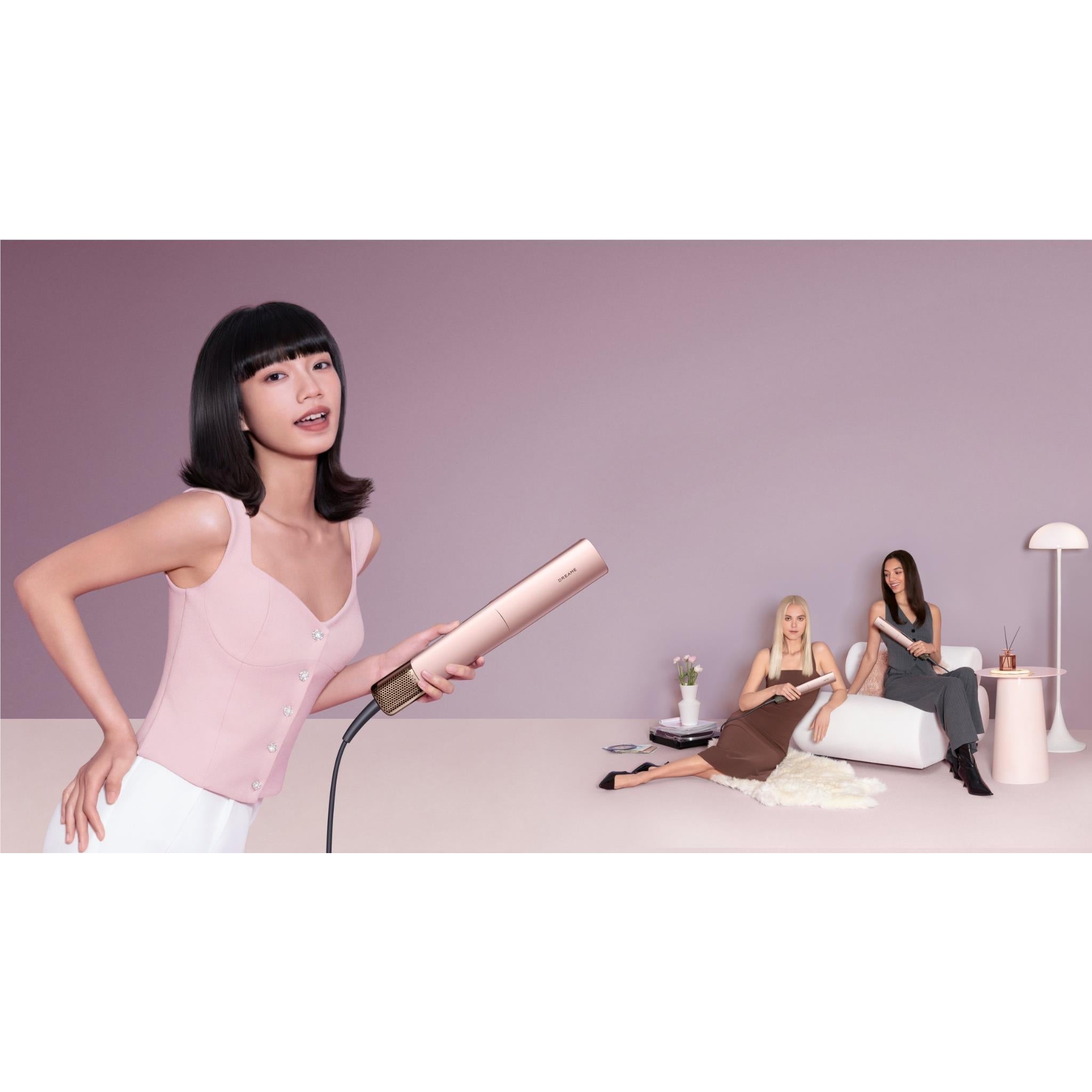 Rose-gold 2-in-1 hair dryer and straightener held in use