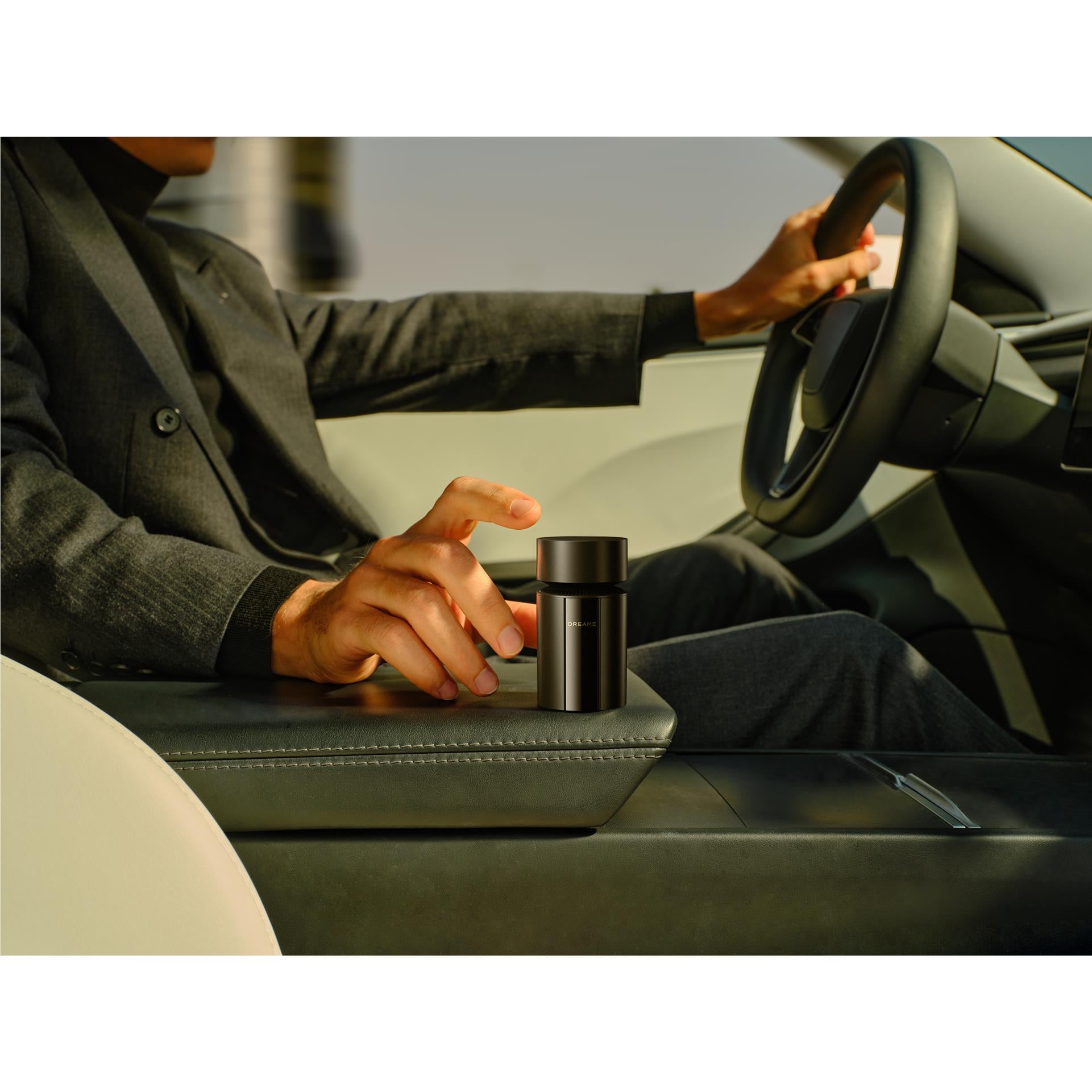 Black electric shaver placed on car seat next to the driver