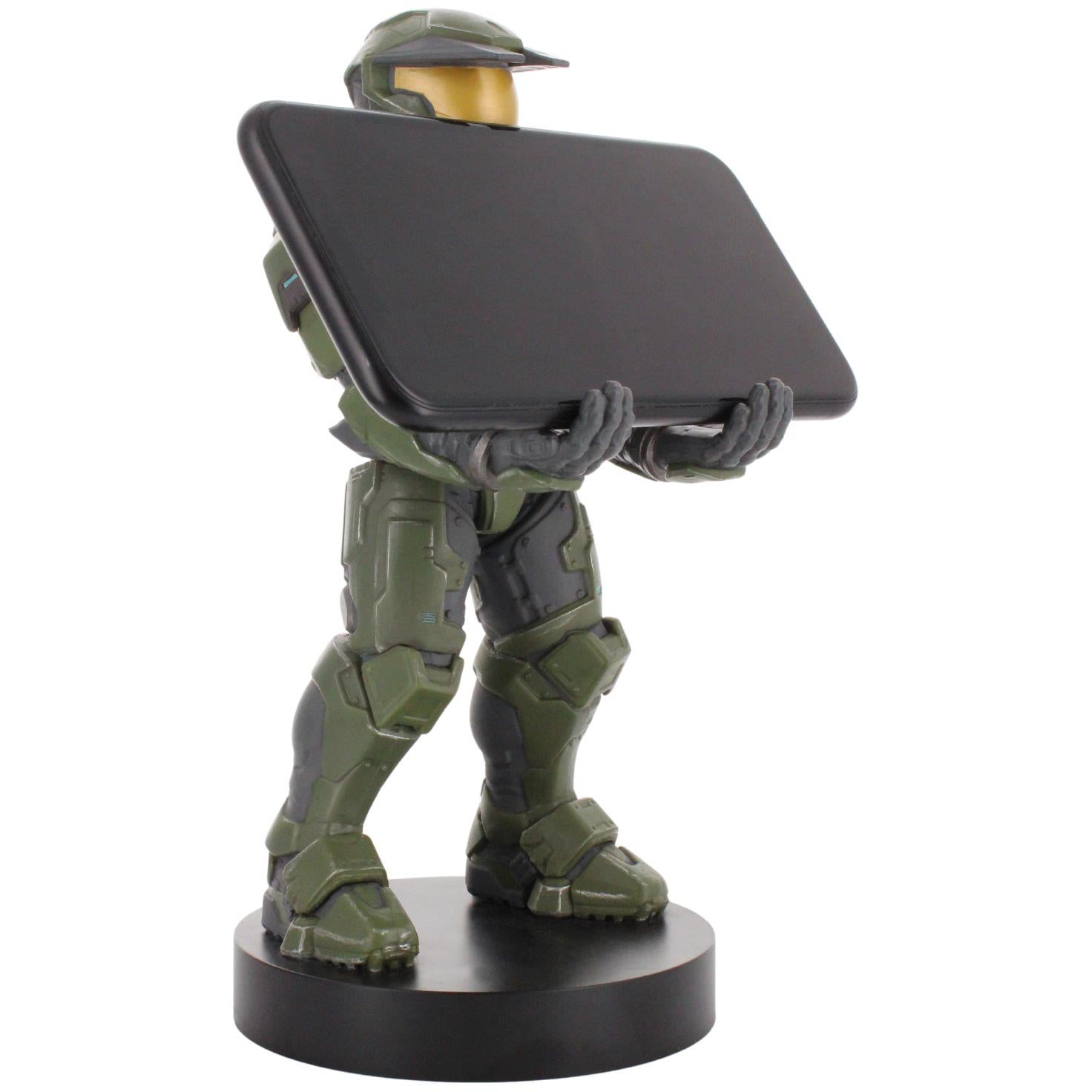 Green armored figure phone stand holding a large dark smartphone, black base