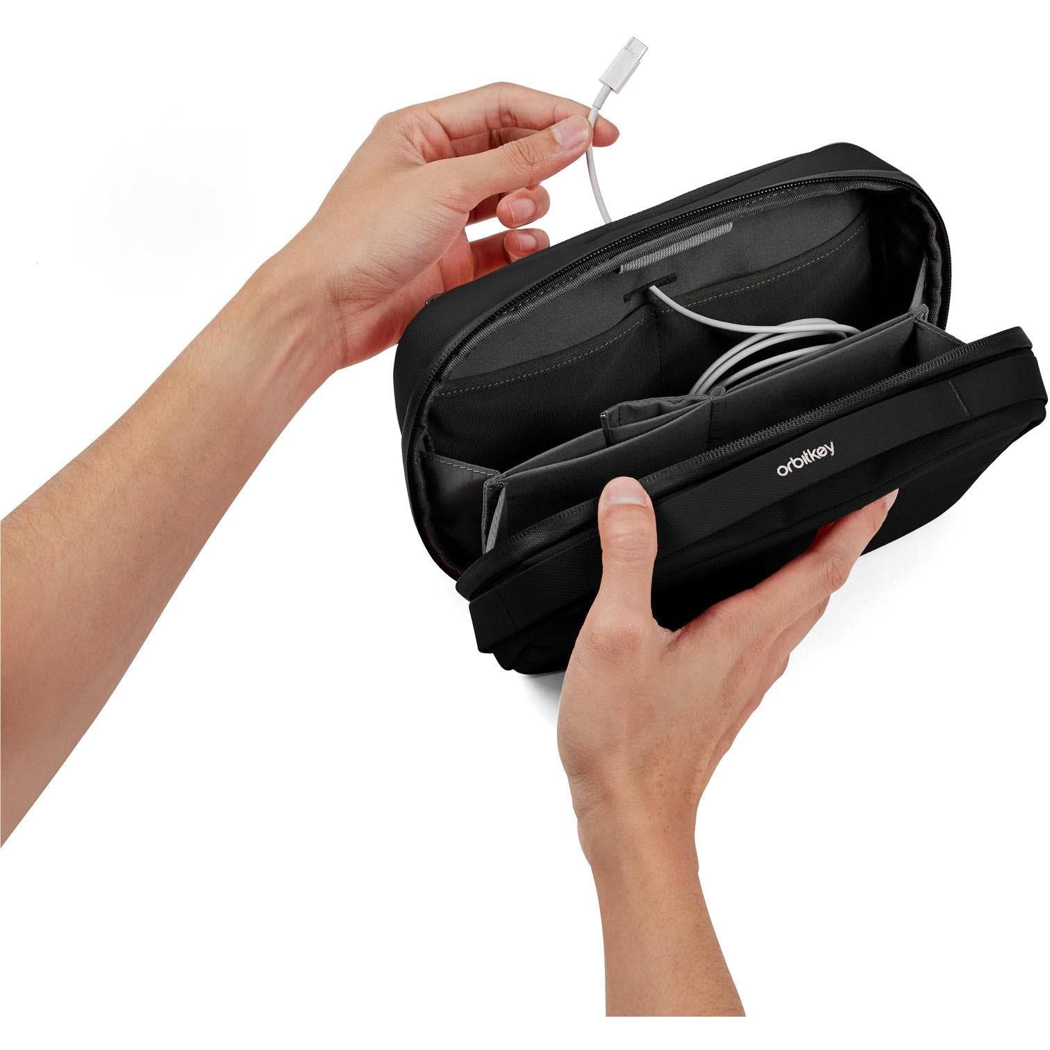 Black expandable tech pouch organiser held open, showing cable and device slots