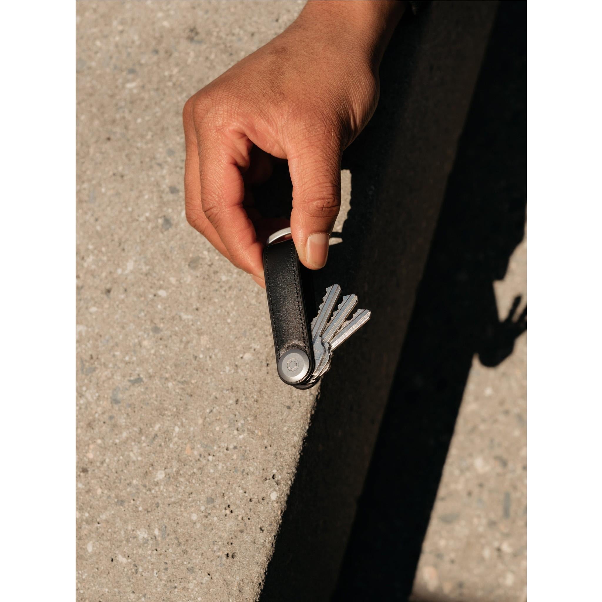 Black leather key organiser held in hand, keys secured on key ring