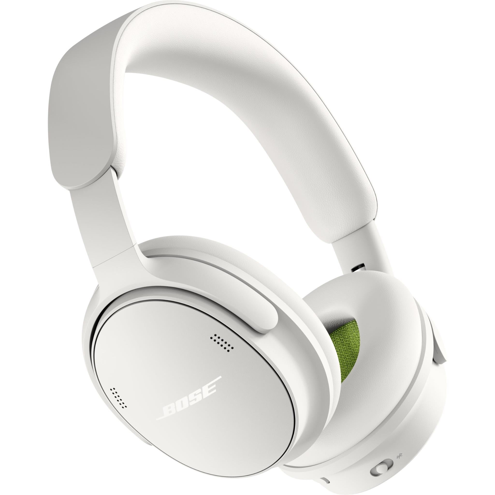 White over-ear stereo headphones with green inner ear cushion, angled view