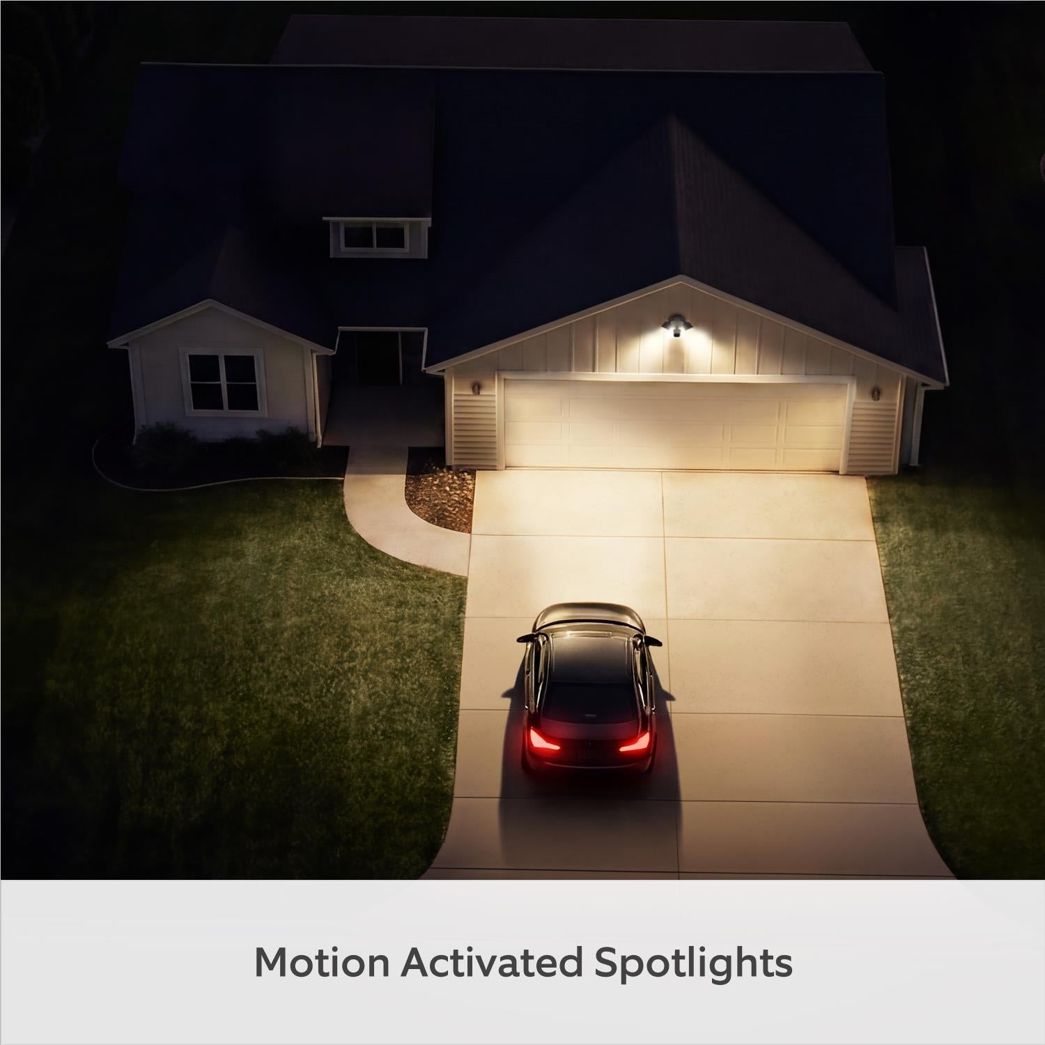 White outdoor floodlight camera on exterior wall with two lit spotlight covers