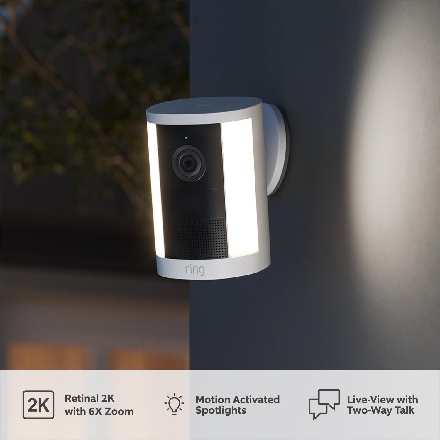White outdoor spotlight security camera with wall-mounted housing