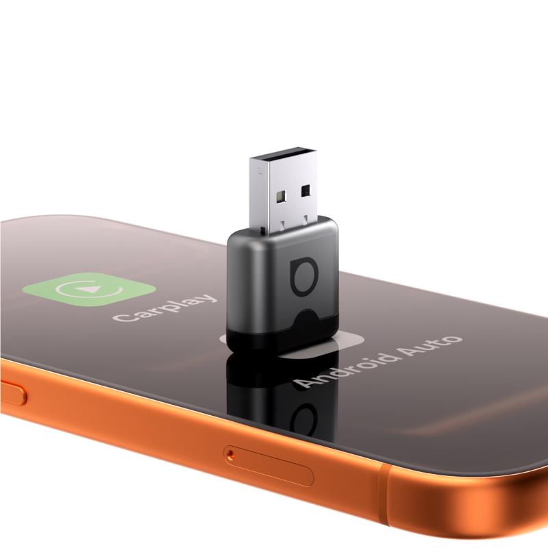 Wireless CarPlay adapter plugged into a smartphone USB port, black housing