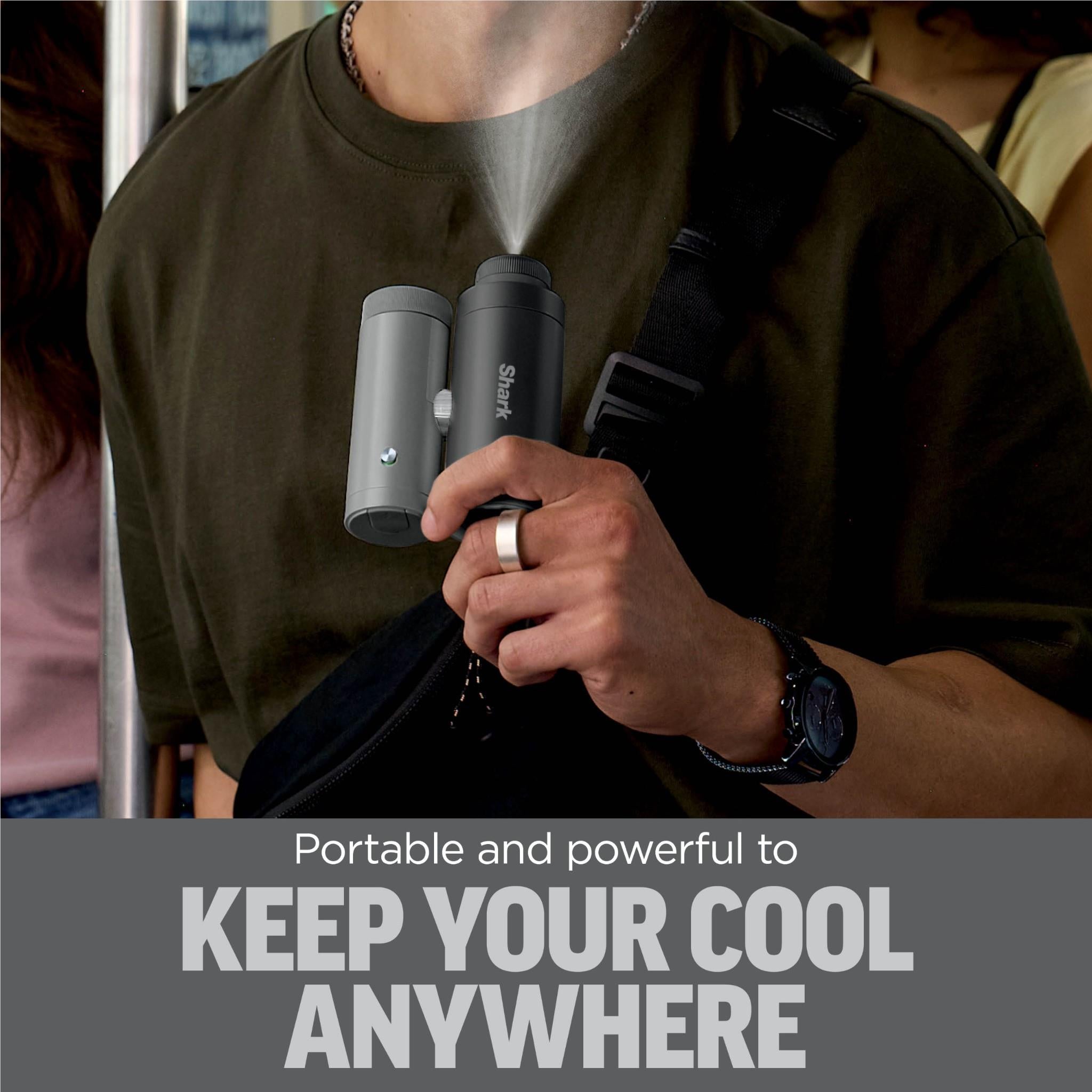 Charcoal handheld cooling fan held in hand with silver attachment