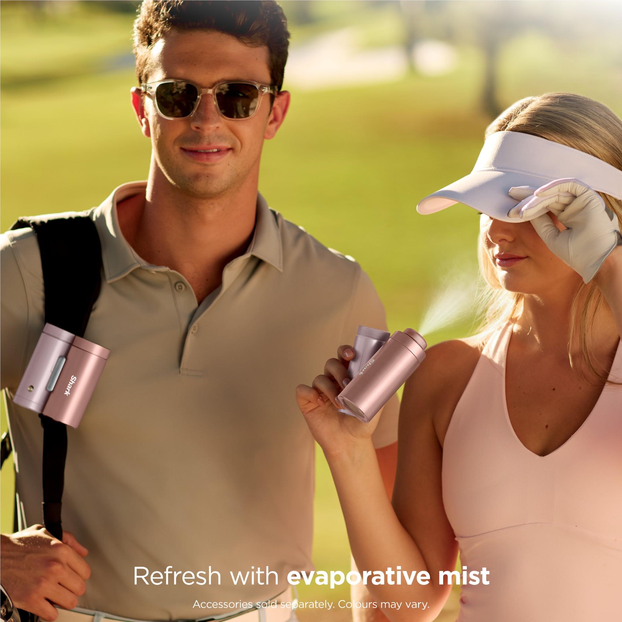 Rose gold handheld fan and mister with misting nozzle, held in hand