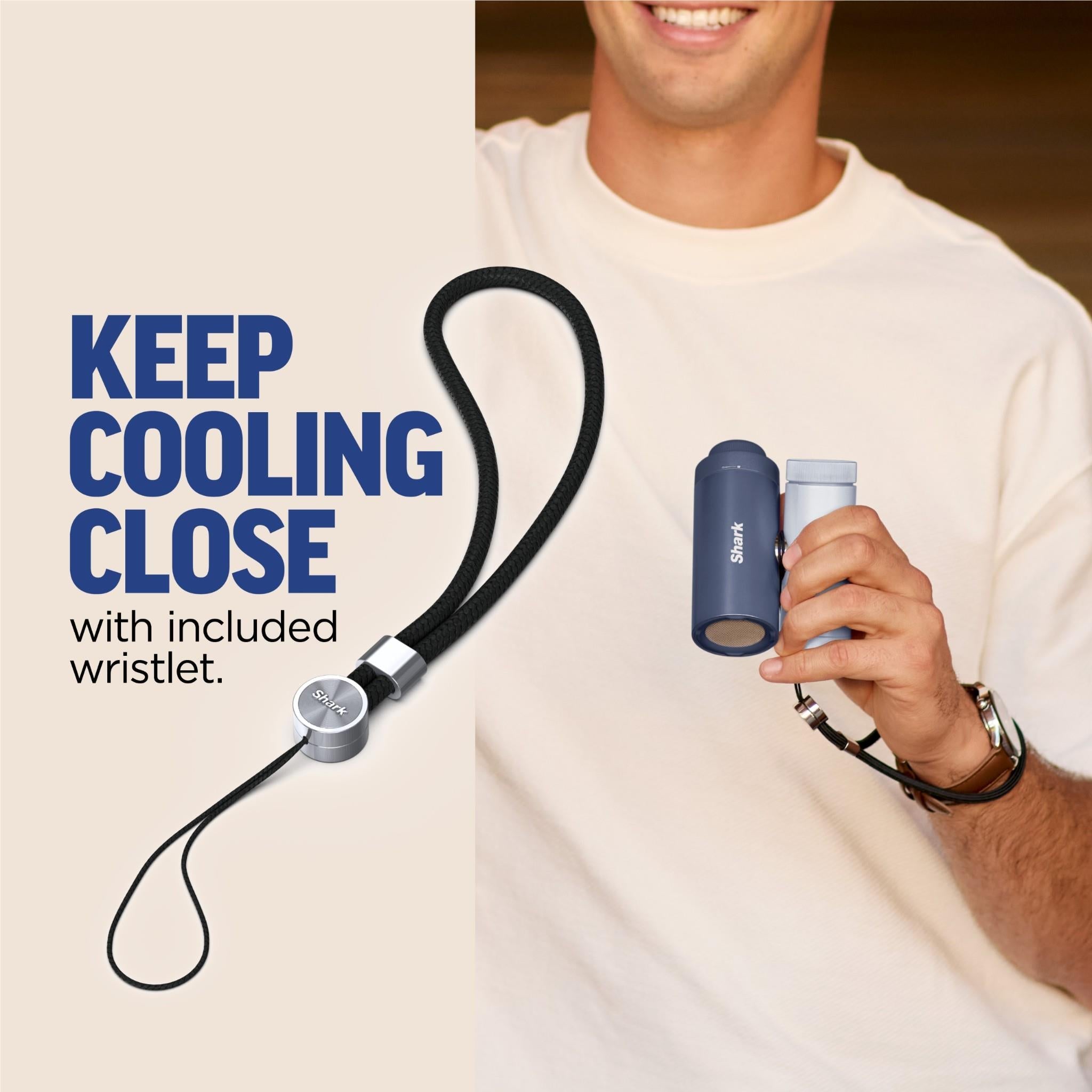 Navy blue handheld fan and mister with wrist strap, held in hand