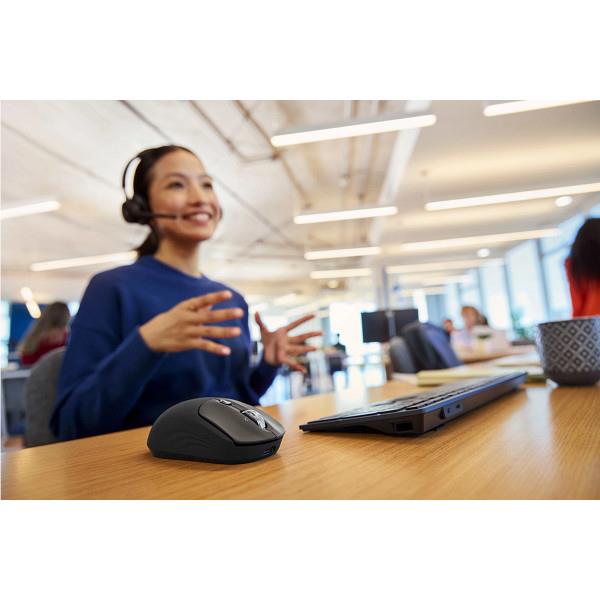 Wireless mouse on desk in office setting, used with a laptop
