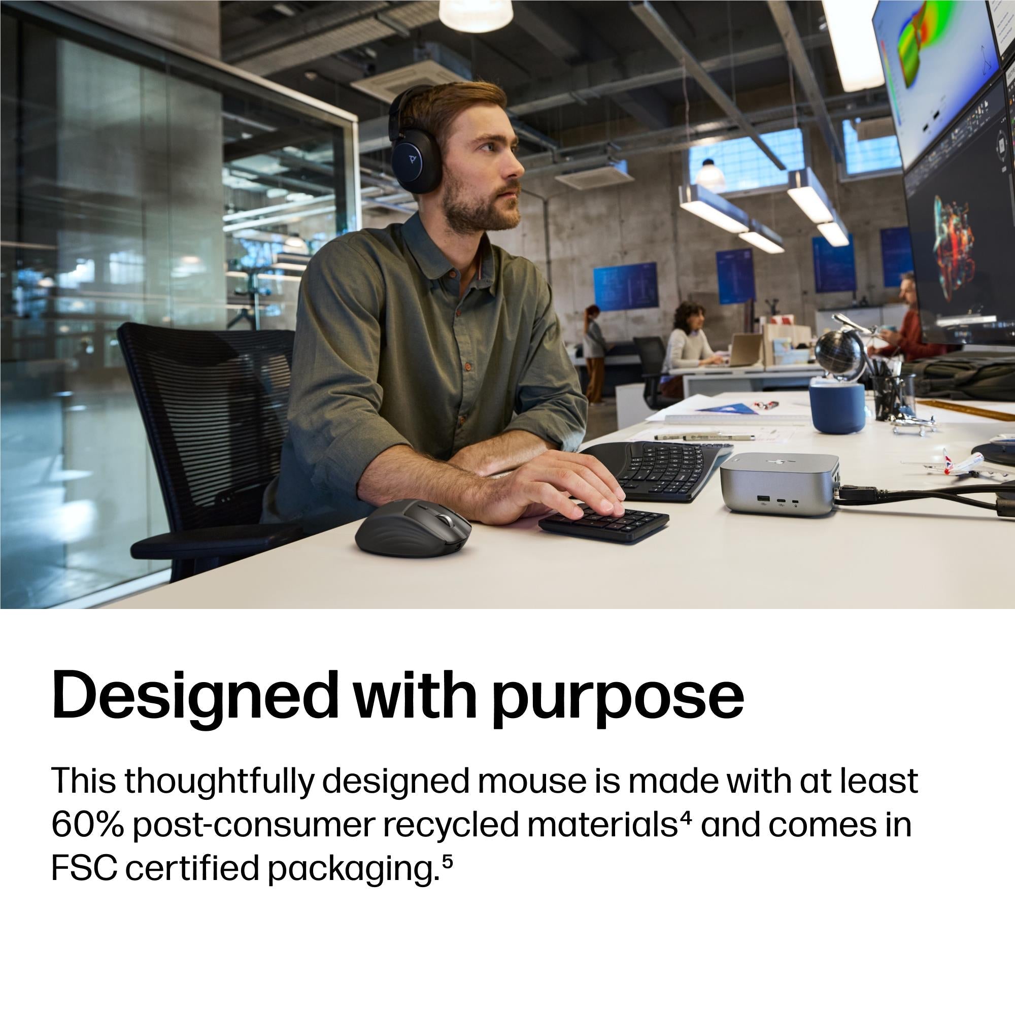 Black wireless mouse on office desk next to a dock, scroll wheel visible