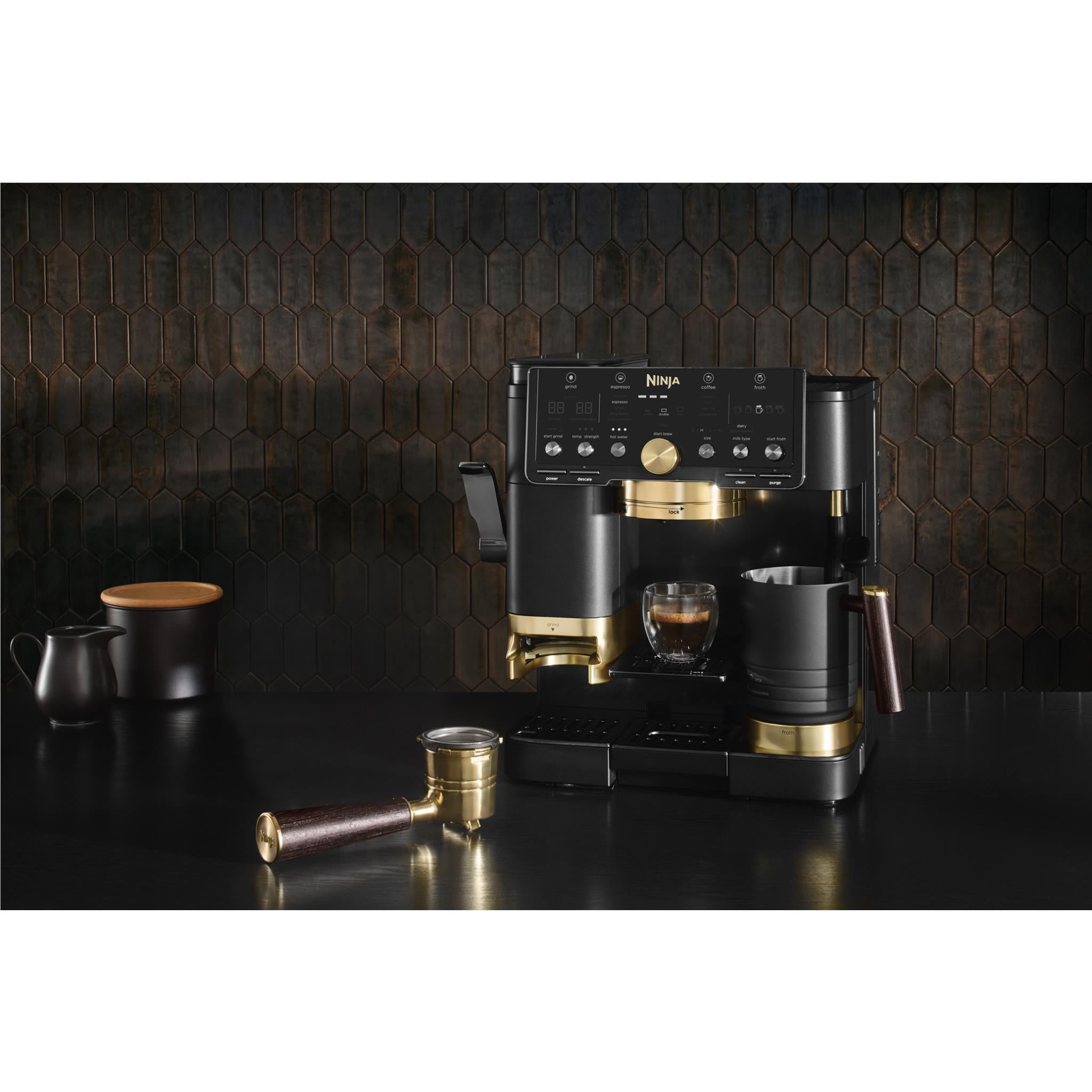 Black Ninja espresso machine with gold accents and accessories on counter