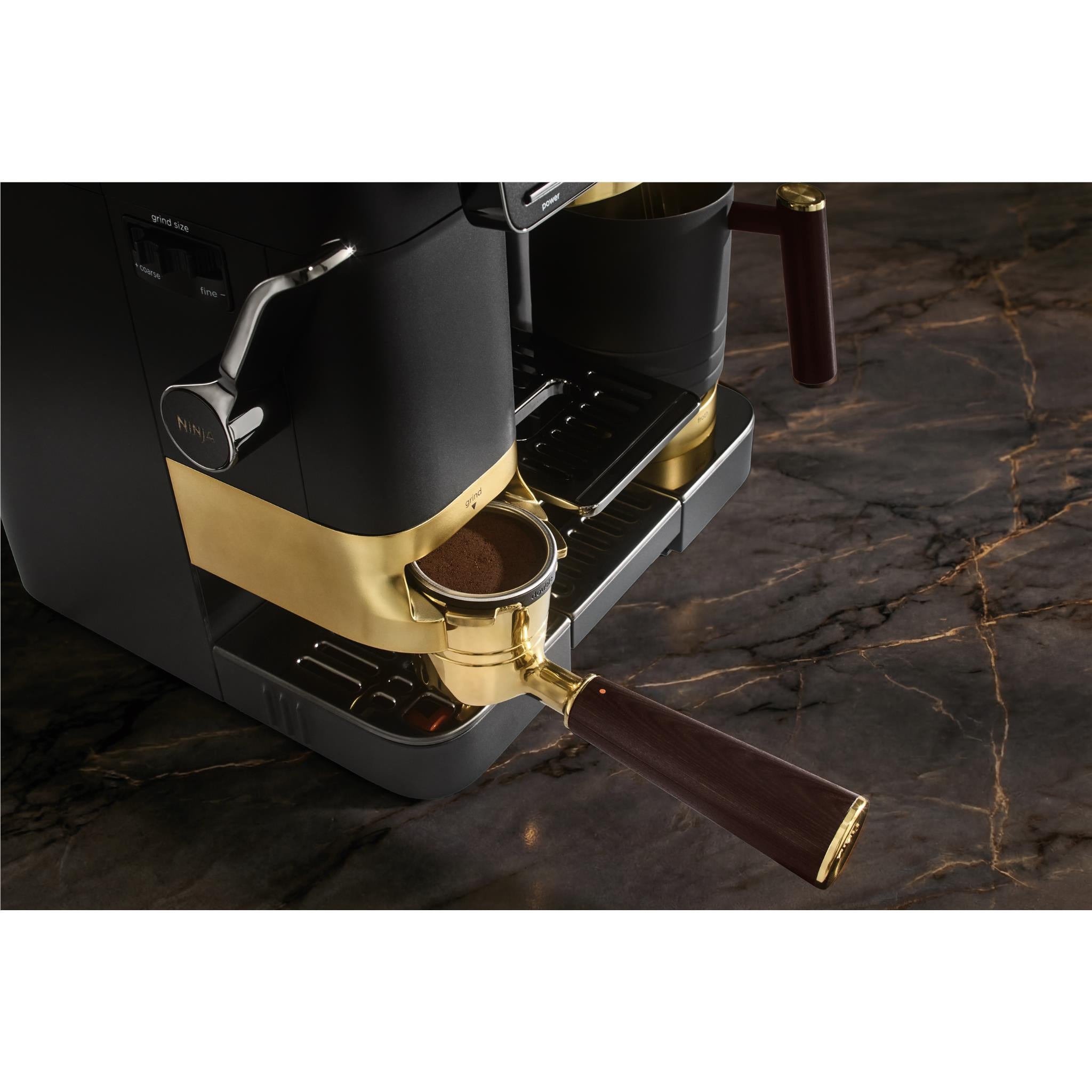 Close-up of Ninja espresso machine portafilter with dark wood handle and coffee drip