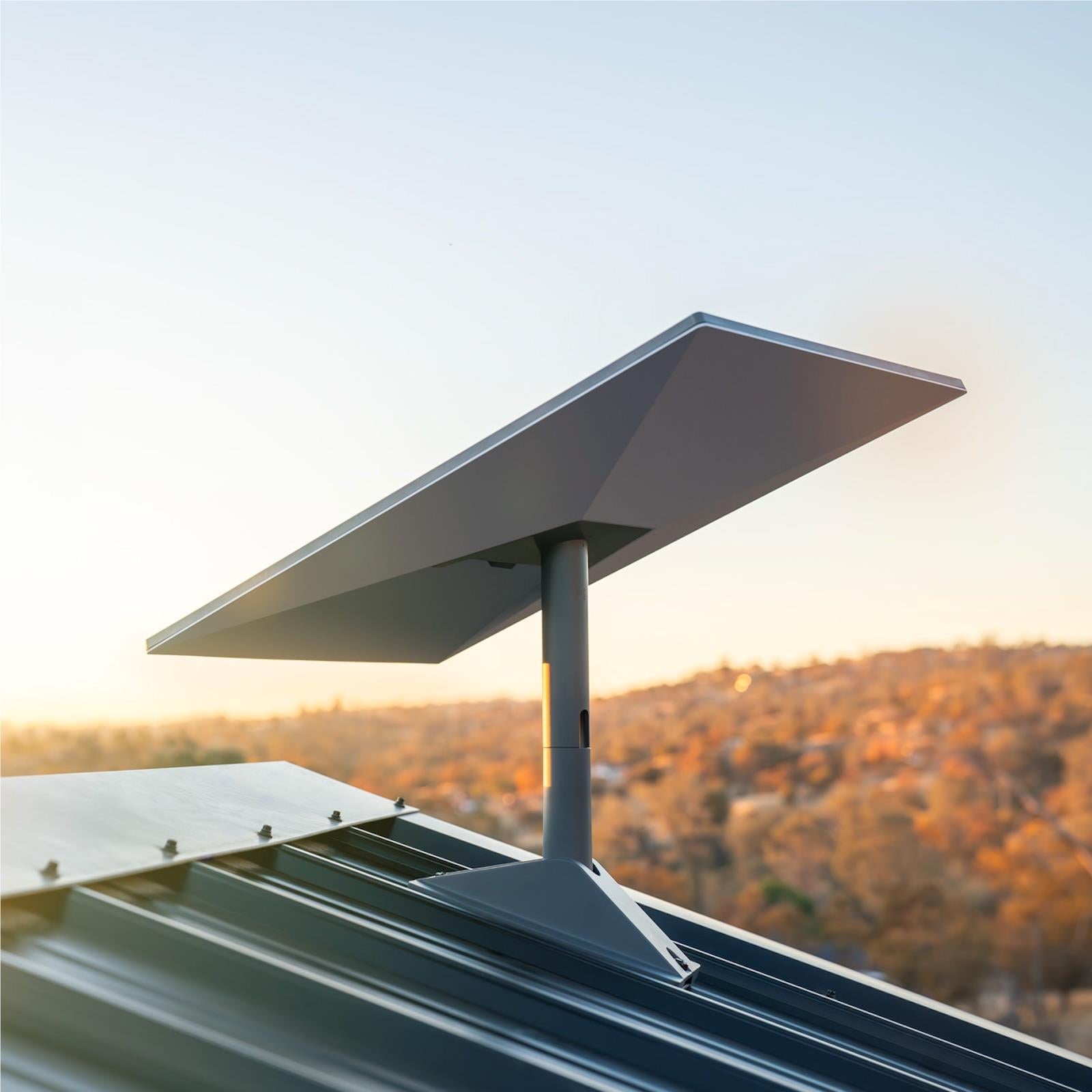 Outdoor satellite internet antenna on roof ledge, dark base and white panel