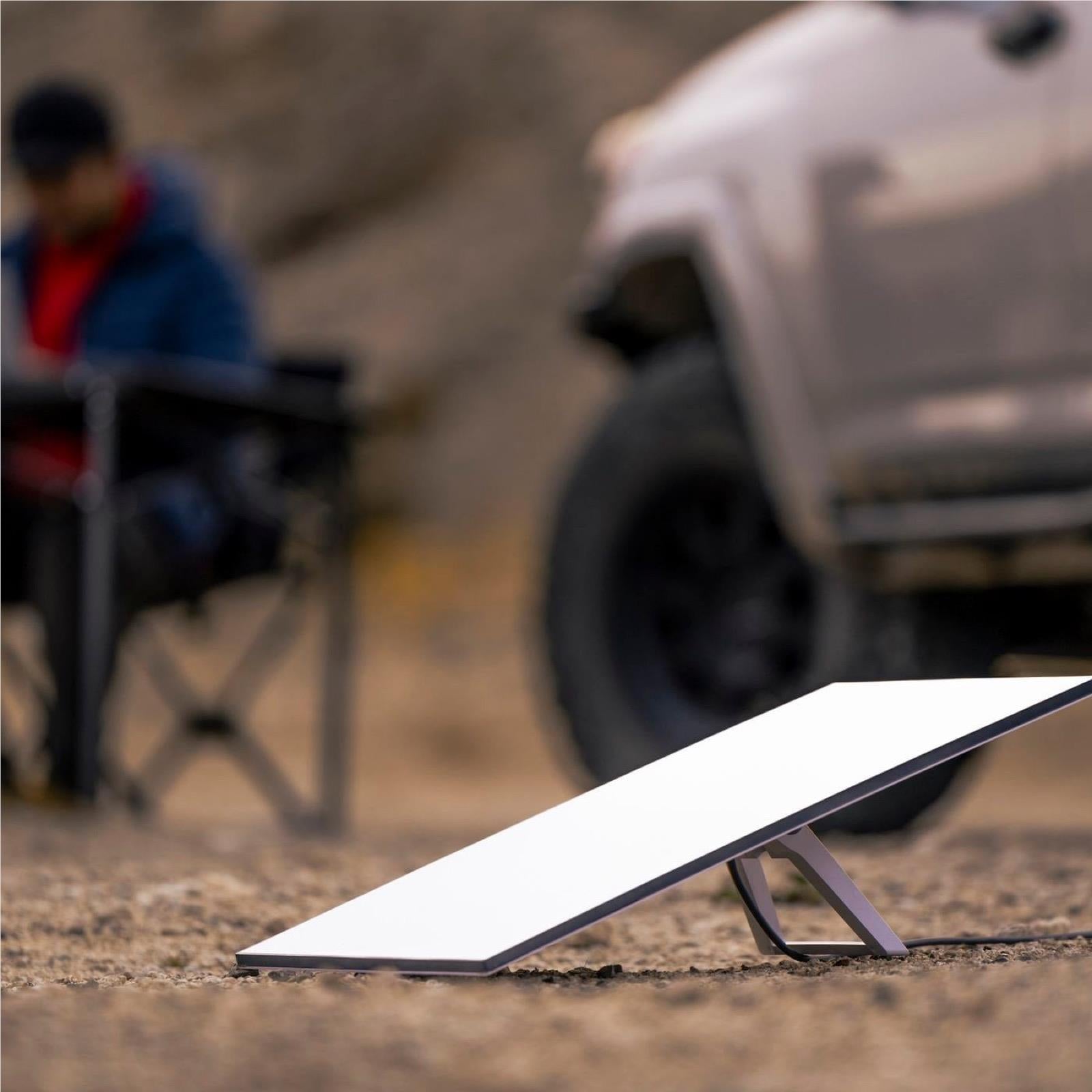 White satellite internet dish on dark stand placed on outdoor ground