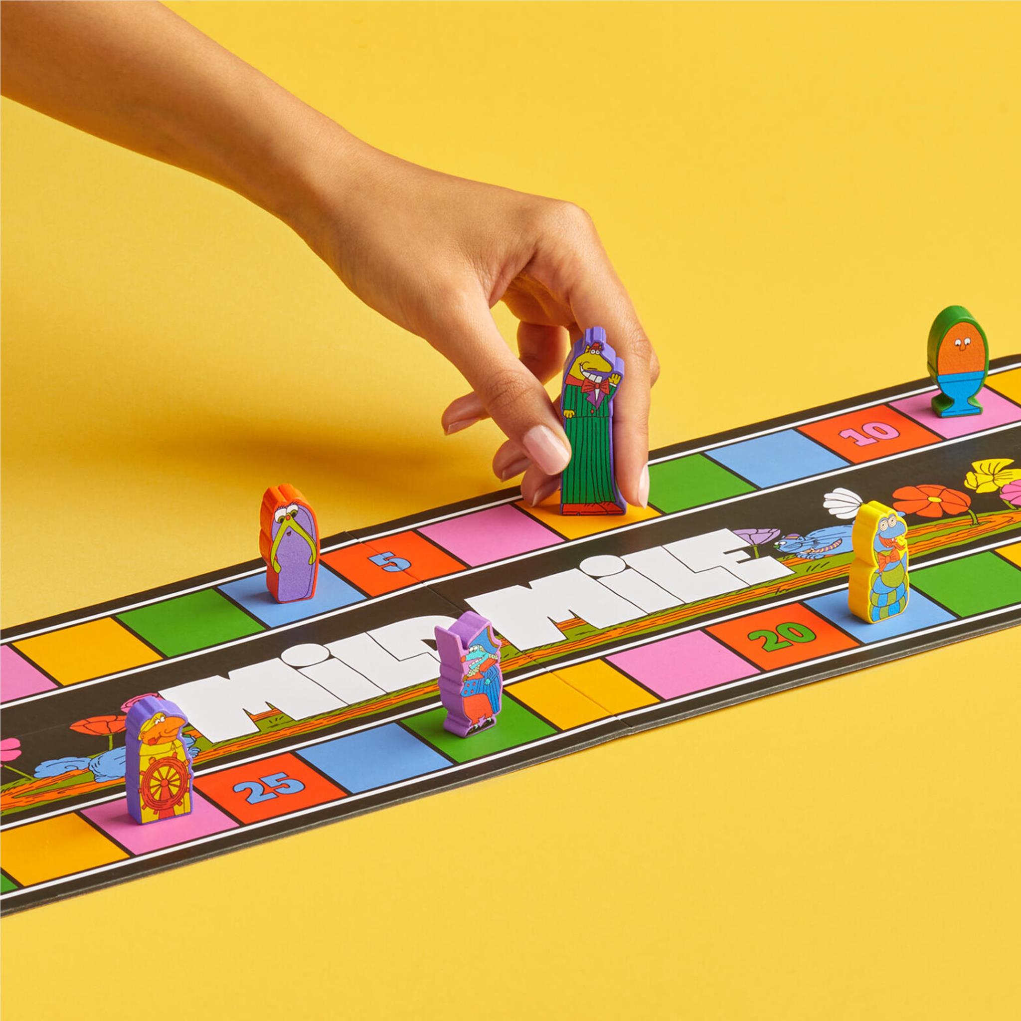 Board game playfield with hand placing racer pieces and number tiles