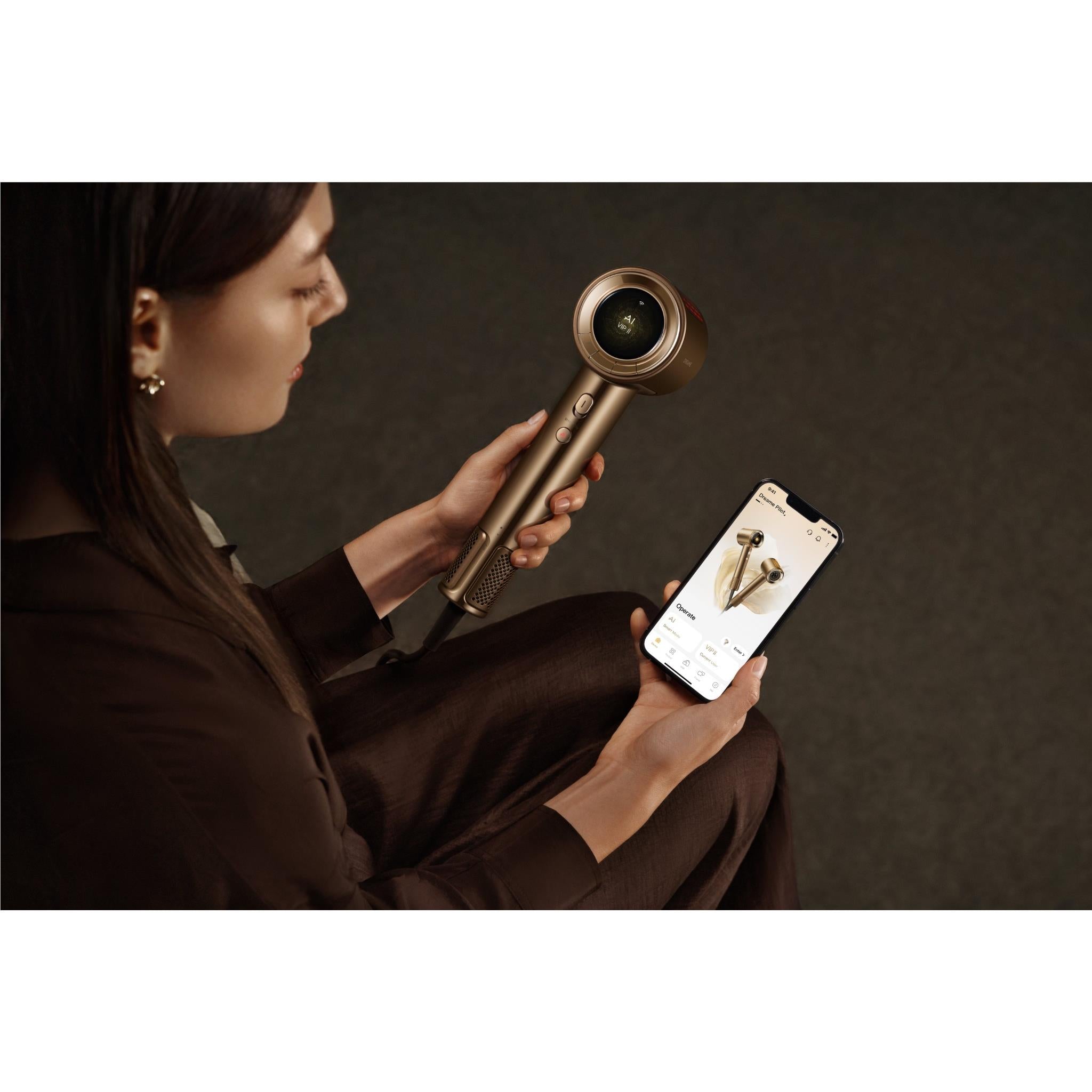 Smart AI hair dryer in gold with concentrator nozzle and app on smartphone