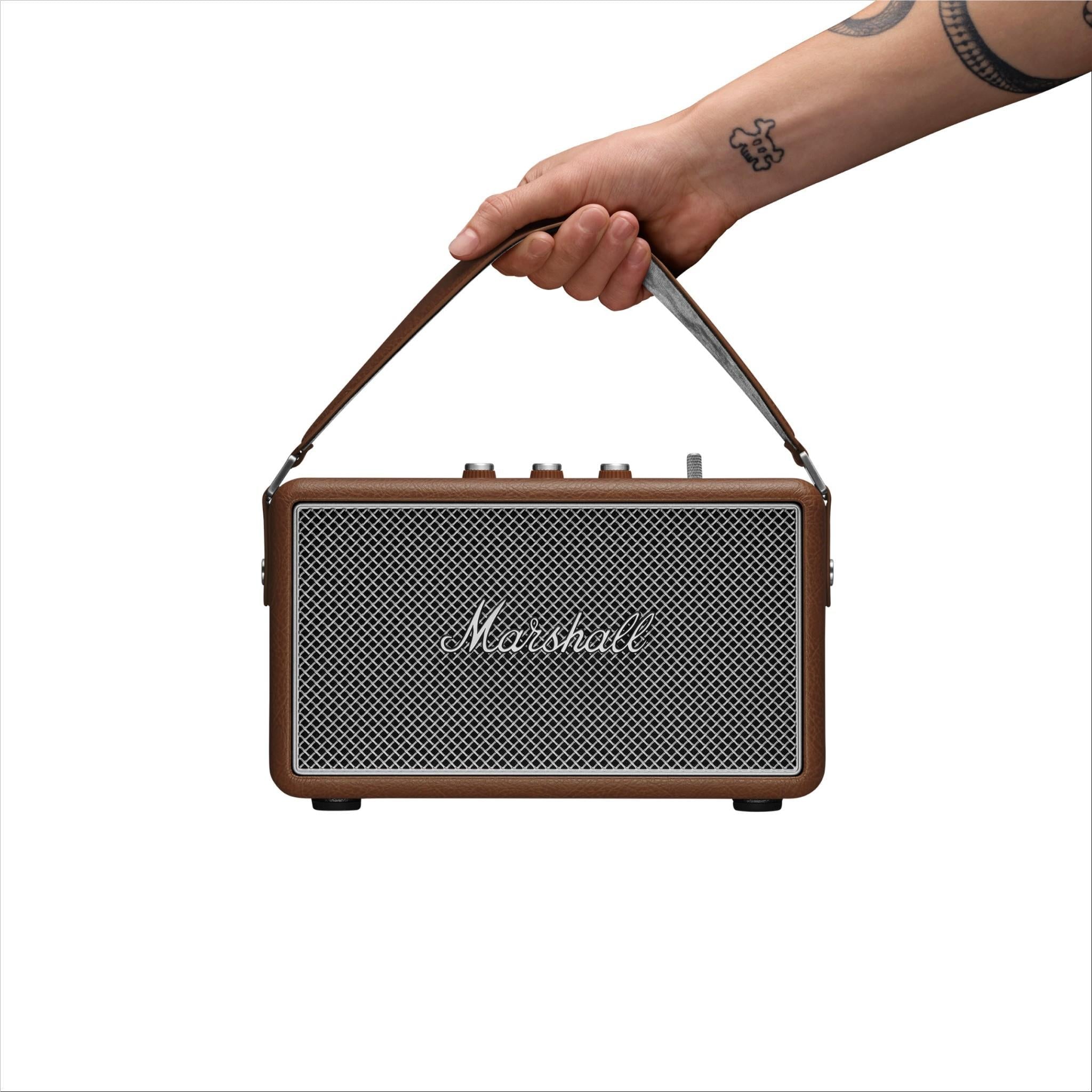 Brown Marshall portable speaker held by hand with mesh front grille