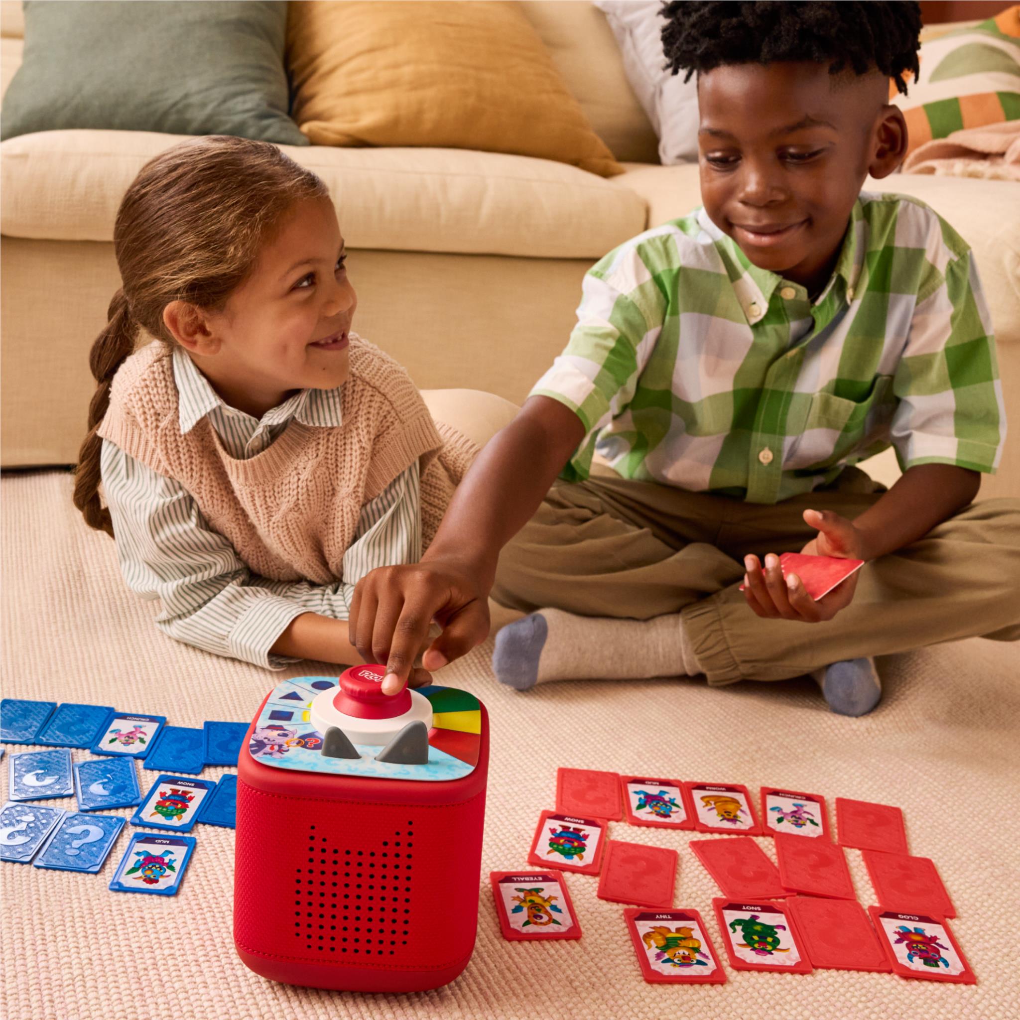 Kids playing with Tonieplay red controller and monster picture cards on a table