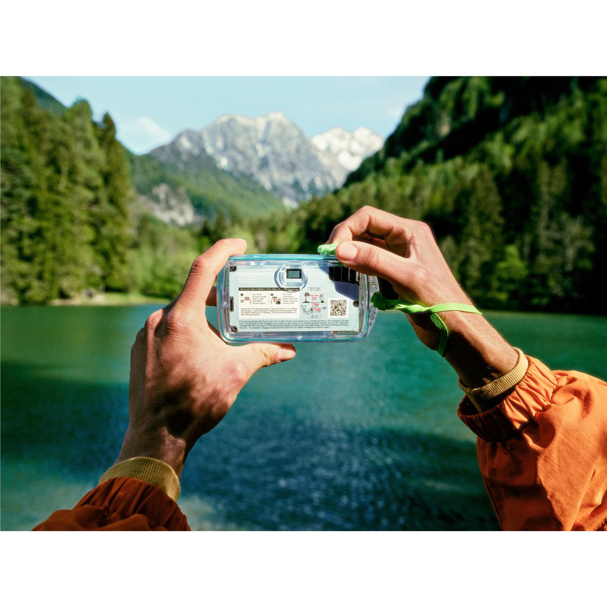 Fujifilm QuickSnap waterproof disposable camera back held up with hands, green strap