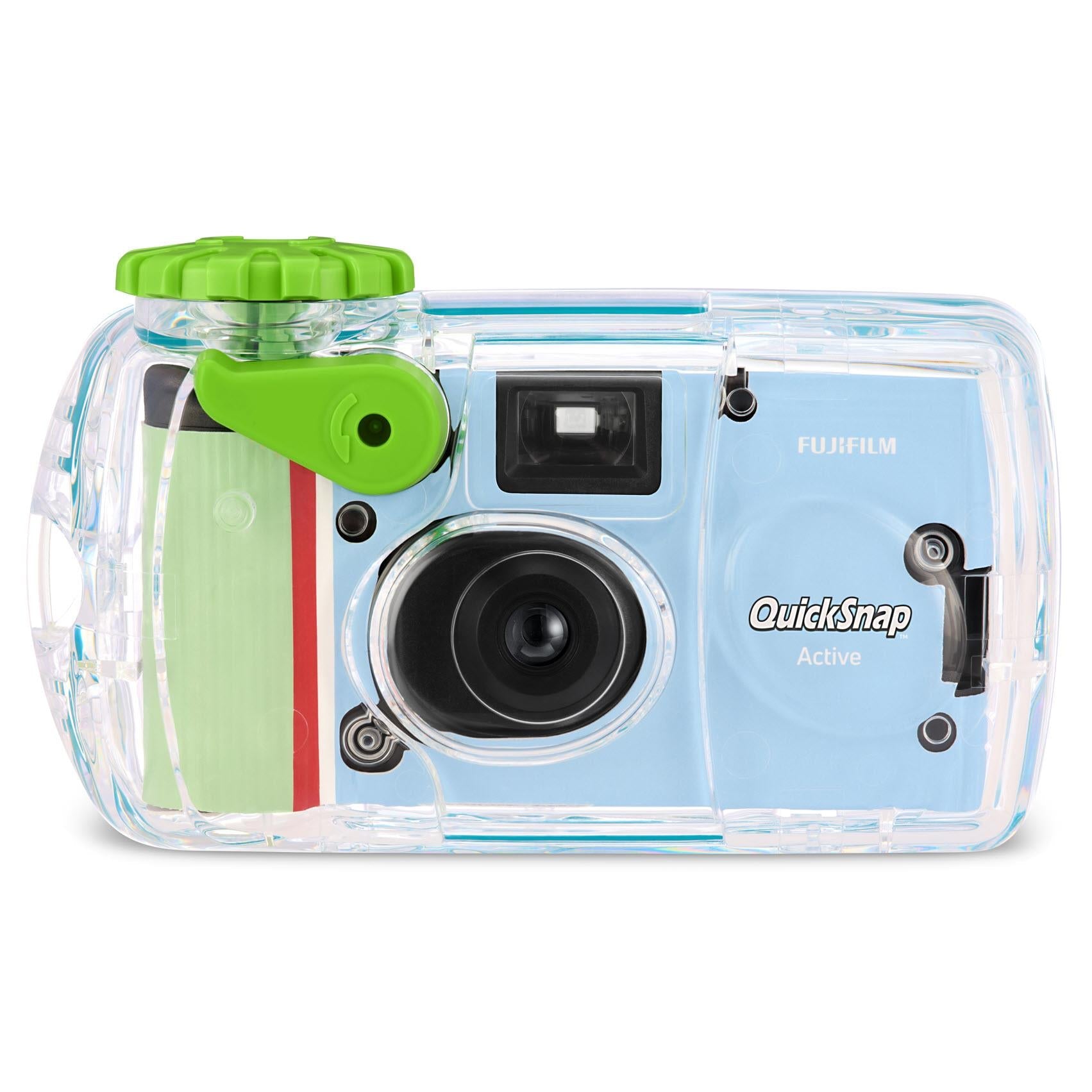Side view of clear disposable camera with green shutter switch and black lens.