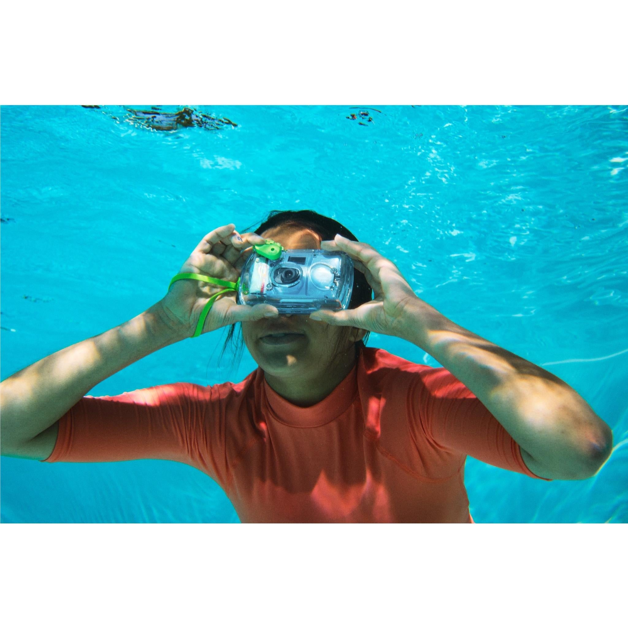Underwater Fujifilm QuickSnap waterproof disposable camera held up by hands, green strap