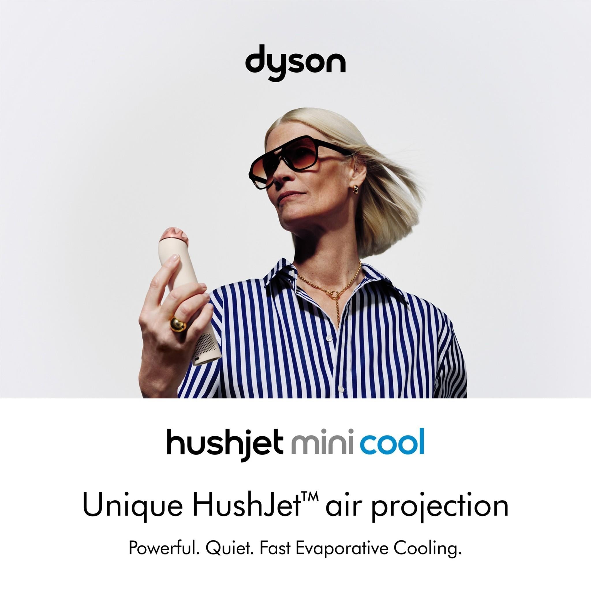 Handheld mini cool fan in stone with blush gold top, held upright in hand