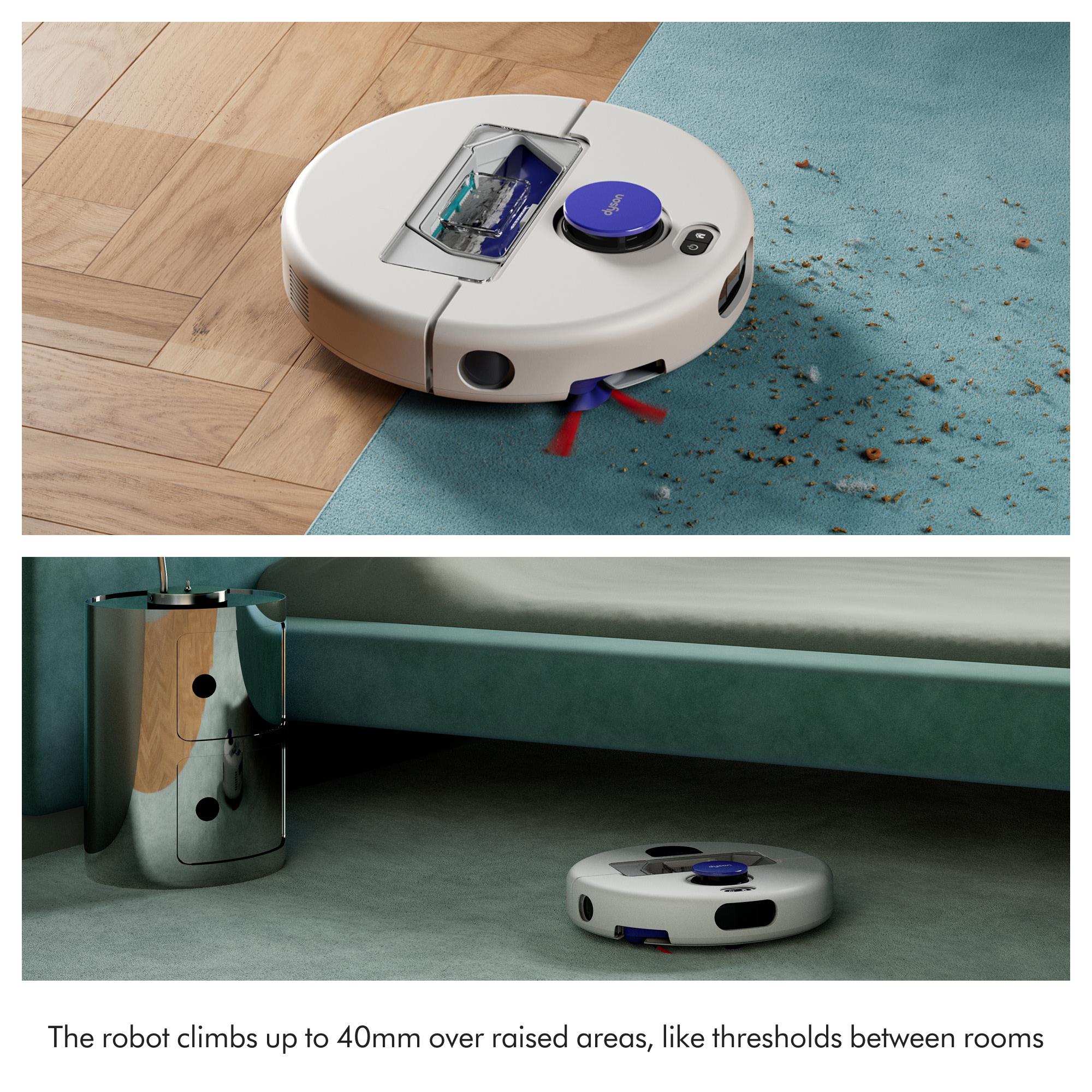 Robot vacuum climbing over a raised threshold with purple top and wheels