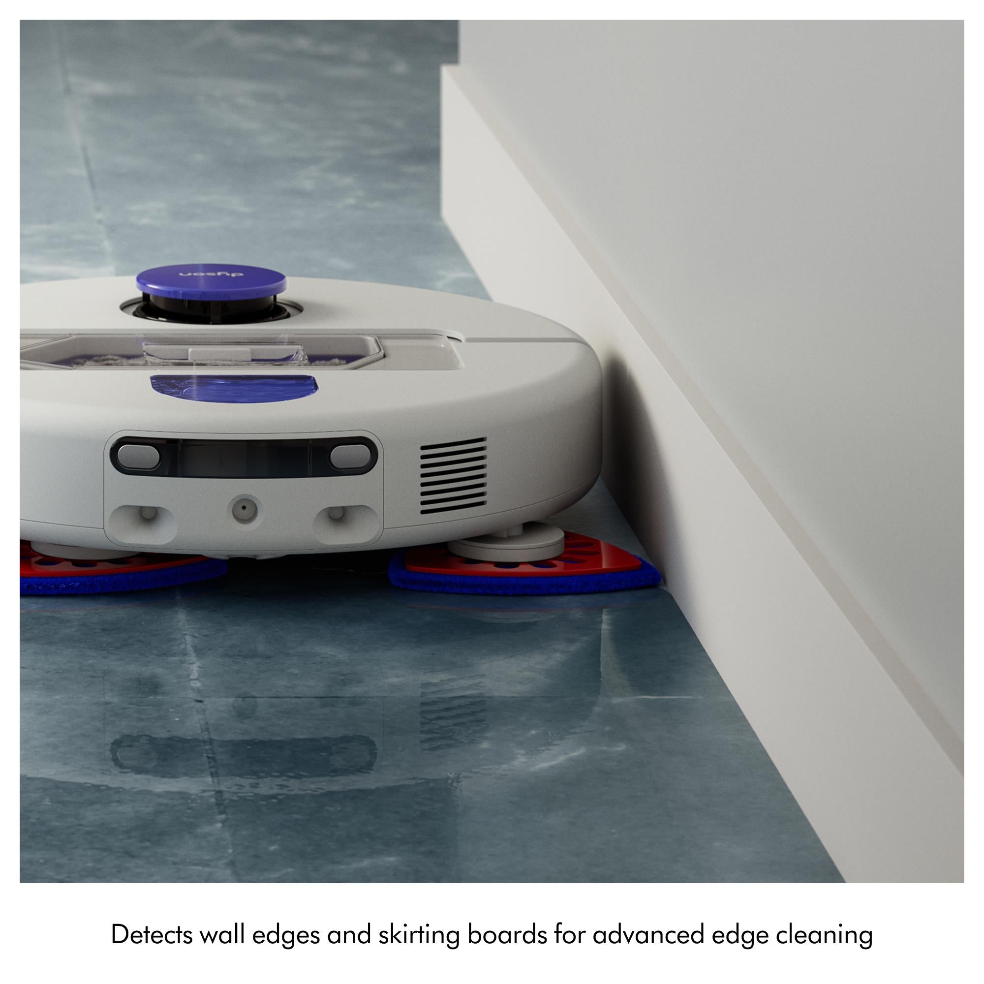 Robot vacuum mop cleaning along a corner with a purple edge pad