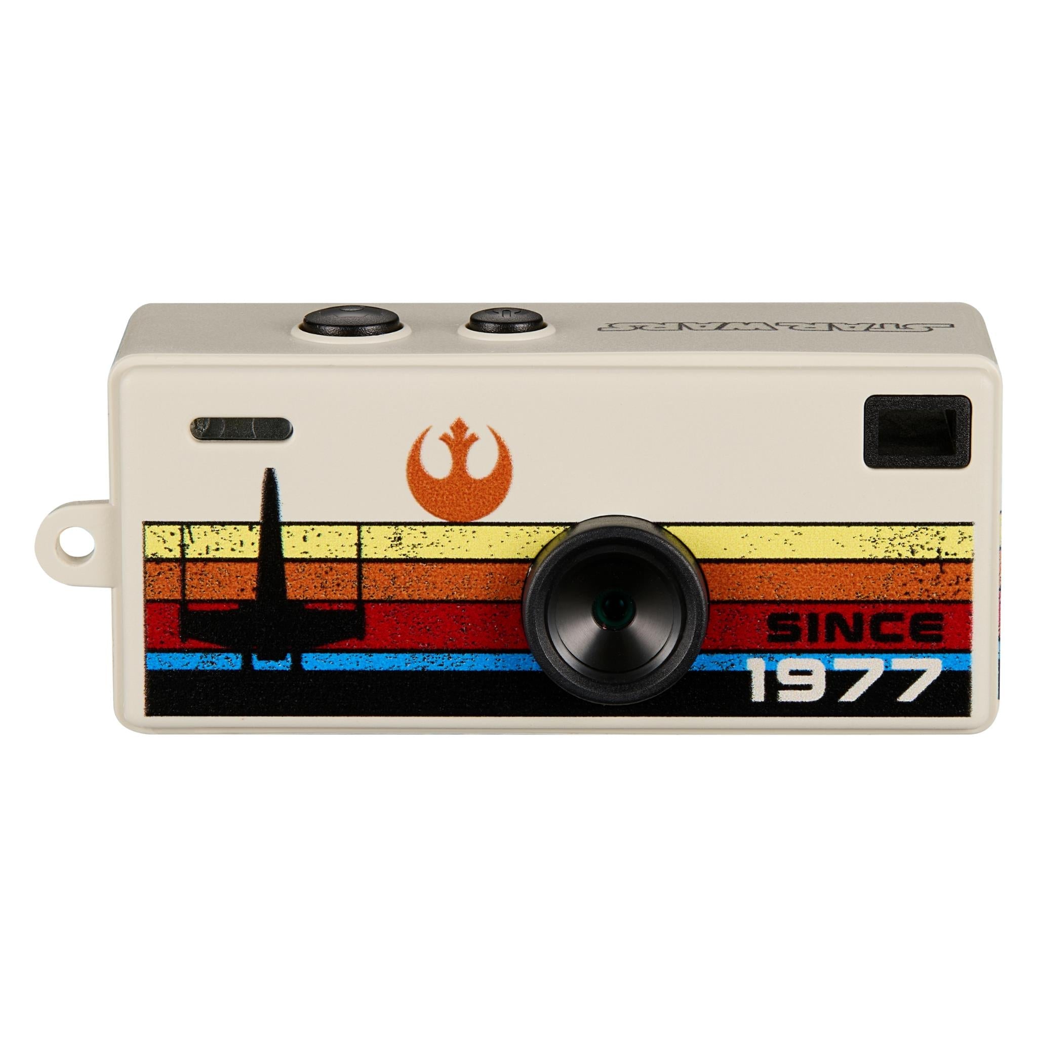 Beige keyring camera with retro graphic stripe, round front lens, and side loop