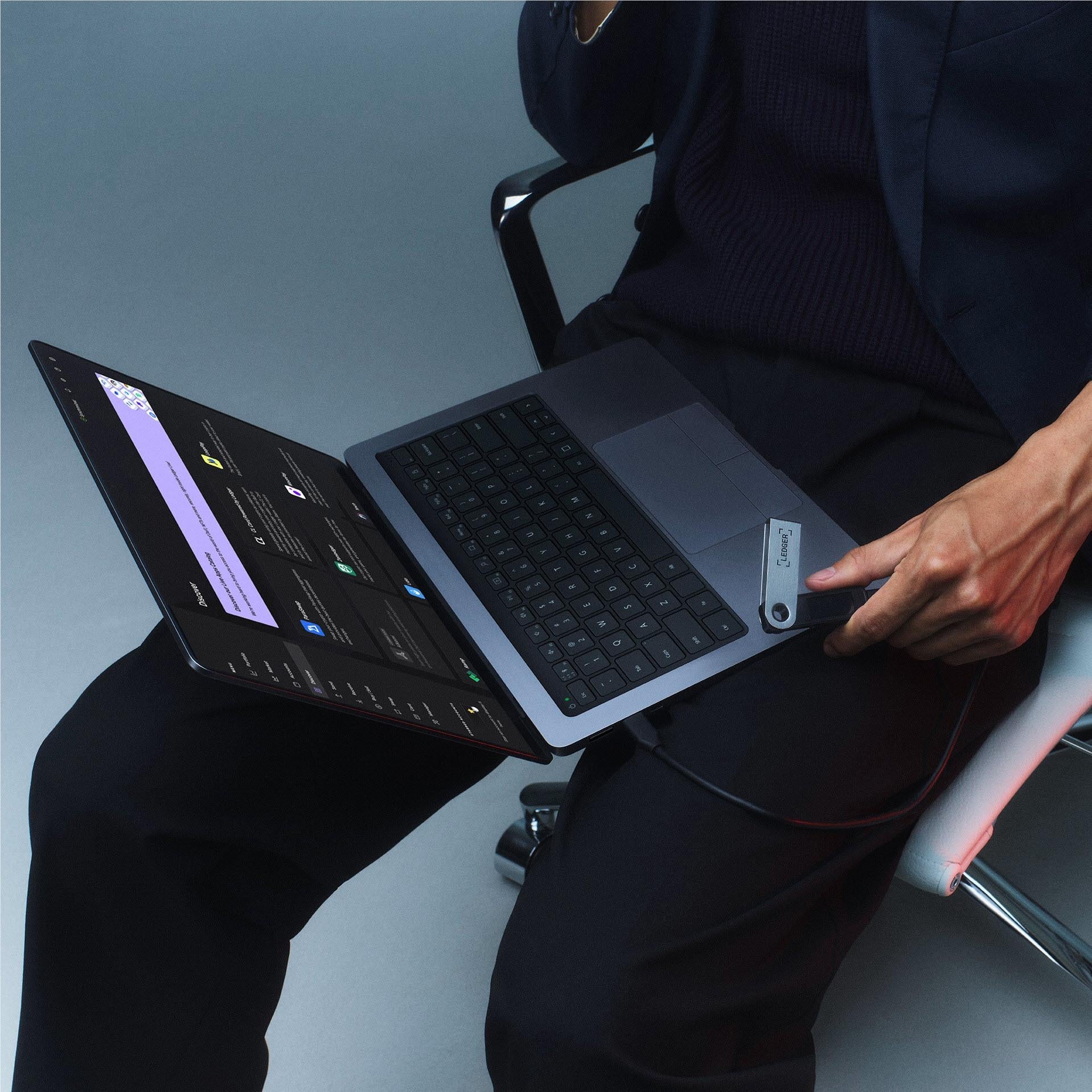 Sapphire blue hardware wallet near laptop and hand