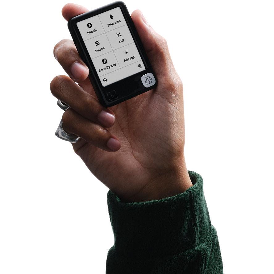 Hand holding a cherry red Ledger hardware wallet with crypto app list on screen