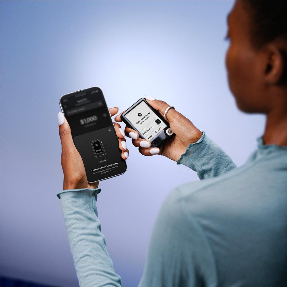 People using a cherry red Ledger hardware wallet connected to a phone app