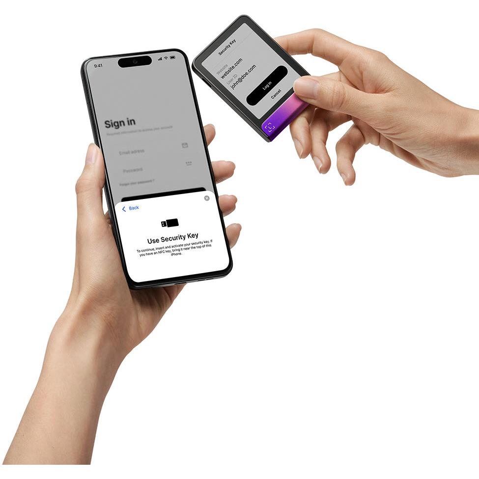 Hardware wallet security key with phone sign-in prompt, dark case and magenta base