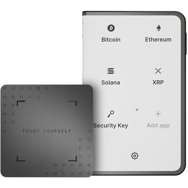 Graphite hardware wallet with crypto app icons on screen and security key beside it