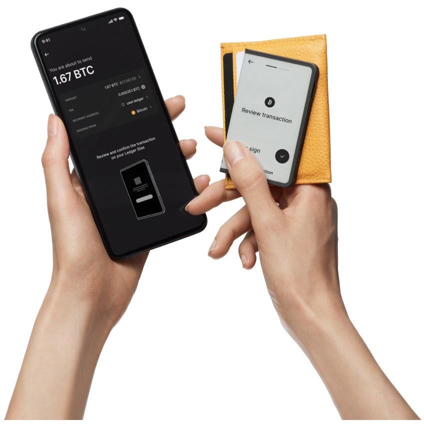 Graphite hardware wallet and security key shown while reviewing and signing on phone