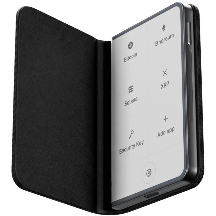 Graphite hardware wallet open in protective case; screen shows crypto app icons