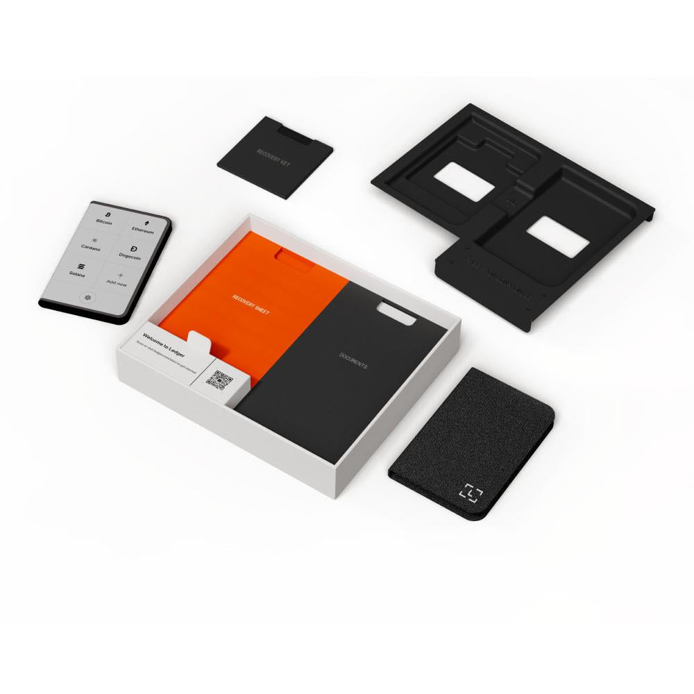 Ledger Stax kit components laid out: hardware wallet, cards, and security key