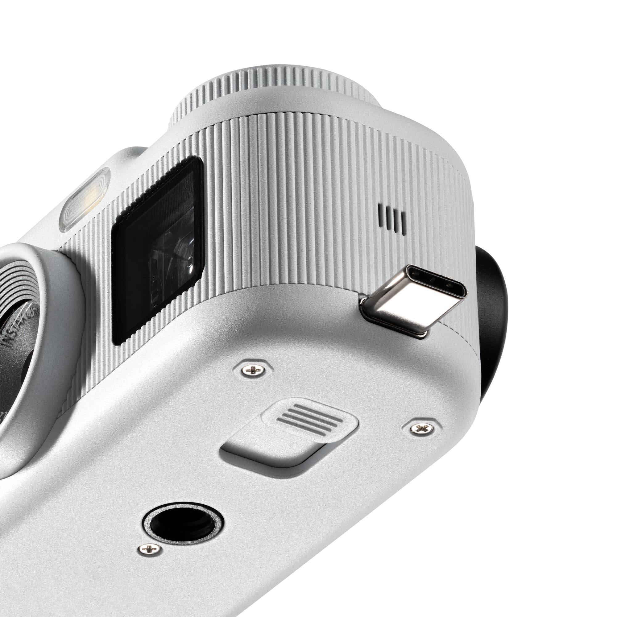 White instax pocket instant camera bottom view with speaker grill and port openings