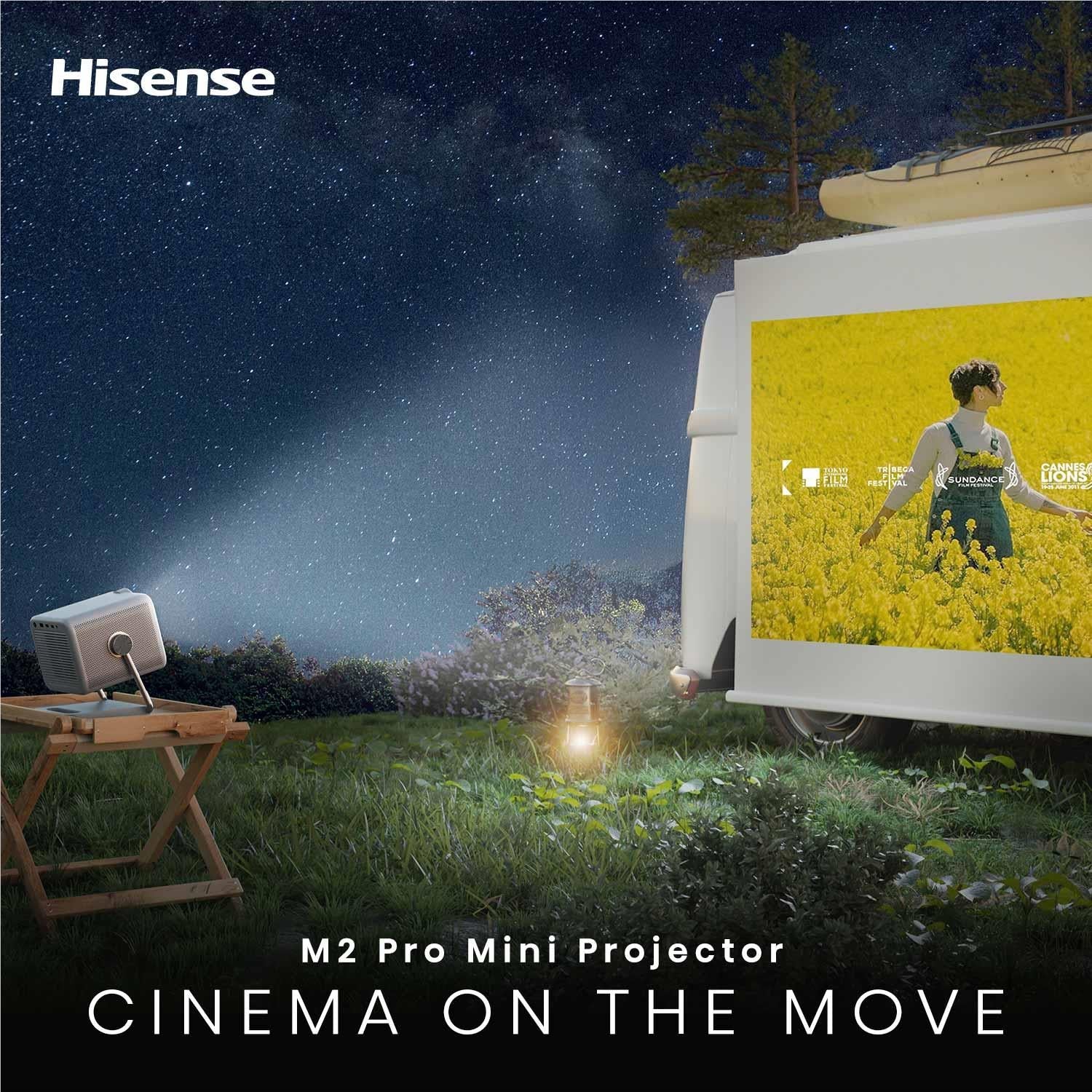 Portable mini projector outdoors on a stand projecting a yellow flower field scene